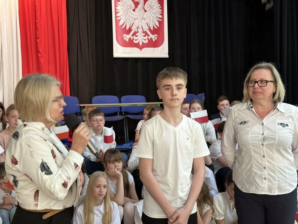 W przeddzień rocznicy uchwalenia Konstytucji 3 Maja w naszej szkole z tej okazji odbył się akademia przygotowana przez uczniów kl. IV a i IV b przy współudziale zespołu wokalnego.
Jego celem było budzenie wrażliwości uczniów na święta narodowe oraz kształtowanie postaw patriotycznych.
Akademia rozpoczęła się uroczystym odśpiewaniem hymnu państwowego. Następnie uczniowie klas czwartych przybliżyli wydarzenia tamtych dni. Zwrócono uwagę na poszanowanie barw narodowych przypominając, iż 2 maja obchodzimy Święto Flagi.
Korzystając z okazji,  pani dyrektor Agnieszka Cieklińska pogratulowała  Marcelowi Chełstowskiemu – Lanzer, uczniowi kl. VII b,  uzyskania  tytułu laureata w Konkursie z  Języka Niemieckiego organizowanego  przez Warmińsko – Mazurskiego Kuratora Oświaty w Olsztynie i wręczyła pamiątkowy dyplom.
Pani dyrektor wręczyła również dyplom pani Annie Cieśli, nauczycielce języka niemieckiego, dziękując za przygotowanie ucznia do konkursu.
Na zakończenie akademii pani Agnieszka Cieklińska życzyła całej społeczności szkolnej radosnego świętowana majowych dni.
