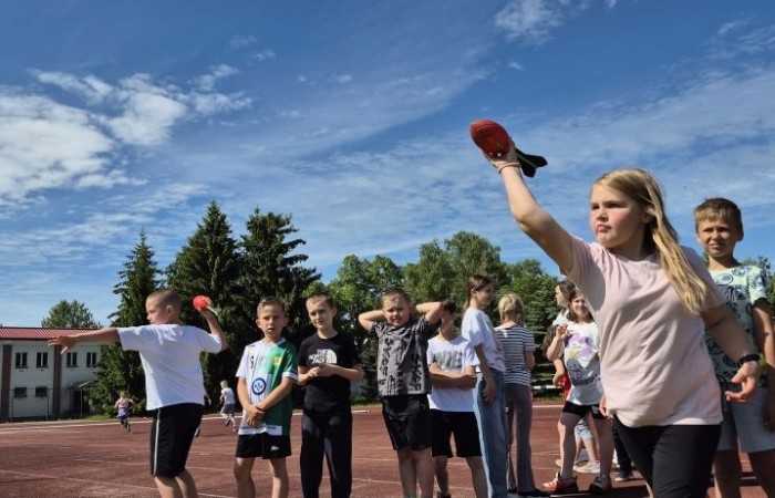 Tegoroczne obchody rozpoczęliśmy twórczo – od przygotowania plakatów „Mistrz zdrowia”. Po tej kreatywnej rozgrzewce przyszedł czas na sportowe emocje. Uroczyste otwarcie było tylko wstępem do licznych atrakcji, które czekały na dzieci na stadionie. Dzięki zaangażowaniu pana Piotra Borysewicza i sportowców z KS Polonia Pasłęk sekcji lekkoatletycznej, uczniowie mogli spróbować swoich sił w biegu przez płotki, rzucie piłeczką oraz torze przeszkód w stylu „Ninja Warrior”. Ogromną atrakcją była również wizyta strażaków z JRG 3 w Pasłęku, którzy zapewnili dzieciom wodno-pianową zabawę. Radość na twarzach uczestników mówiła sama za siebie. Na wszystkich zgłodniałych czekały pyszności, w tym słodka wata cukrowa, serwowana przez Panie z Koła Gospodyń Wiejskich w Borzynowie. Szczególne podziękowania kierujemy do niezastąpionych Rodziców – za wsparcie organizacyjne, opiekę podczas wydarzenia oraz przygotowanie dodatkowych atrakcji: plenerowego studia malowania twarzy i tatuaży. Na zakończenie nikt nie wyszedł z pustymi rękami – niezależnie od wyników konkursów każdy uczeń otrzymał drobny upominek i medal. To wyjątkowe święto pełne radości i zabawy już za nami, więc zaczynamy odliczanie do kolejnego Dnia Dziecka!