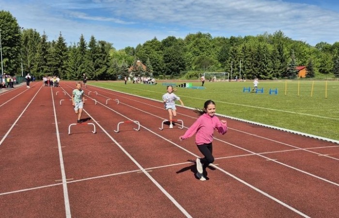 Tegoroczne obchody rozpoczęliśmy twórczo – od przygotowania plakatów „Mistrz zdrowia”. Po tej kreatywnej rozgrzewce przyszedł czas na sportowe emocje. Uroczyste otwarcie było tylko wstępem do licznych atrakcji, które czekały na dzieci na stadionie. Dzięki zaangażowaniu pana Piotra Borysewicza i sportowców z KS Polonia Pasłęk sekcji lekkoatletycznej, uczniowie mogli spróbować swoich sił w biegu przez płotki, rzucie piłeczką oraz torze przeszkód w stylu „Ninja Warrior”. Ogromną atrakcją była również wizyta strażaków z JRG 3 w Pasłęku, którzy zapewnili dzieciom wodno-pianową zabawę. Radość na twarzach uczestników mówiła sama za siebie. Na wszystkich zgłodniałych czekały pyszności, w tym słodka wata cukrowa, serwowana przez Panie z Koła Gospodyń Wiejskich w Borzynowie. Szczególne podziękowania kierujemy do niezastąpionych Rodziców – za wsparcie organizacyjne, opiekę podczas wydarzenia oraz przygotowanie dodatkowych atrakcji: plenerowego studia malowania twarzy i tatuaży. Na zakończenie nikt nie wyszedł z pustymi rękami – niezależnie od wyników konkursów każdy uczeń otrzymał drobny upominek i medal. To wyjątkowe święto pełne radości i zabawy już za nami, więc zaczynamy odliczanie do kolejnego Dnia Dziecka!