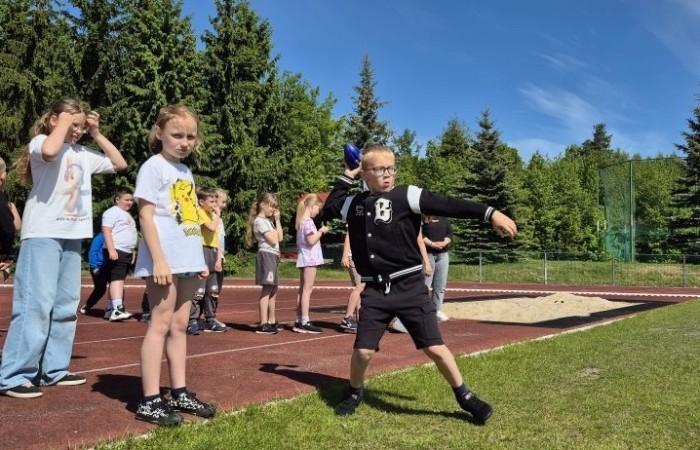 Tegoroczne obchody rozpoczęliśmy twórczo – od przygotowania plakatów „Mistrz zdrowia”. Po tej kreatywnej rozgrzewce przyszedł czas na sportowe emocje. Uroczyste otwarcie było tylko wstępem do licznych atrakcji, które czekały na dzieci na stadionie. Dzięki zaangażowaniu pana Piotra Borysewicza i sportowców z KS Polonia Pasłęk sekcji lekkoatletycznej, uczniowie mogli spróbować swoich sił w biegu przez płotki, rzucie piłeczką oraz torze przeszkód w stylu „Ninja Warrior”. Ogromną atrakcją była również wizyta strażaków z JRG 3 w Pasłęku, którzy zapewnili dzieciom wodno-pianową zabawę. Radość na twarzach uczestników mówiła sama za siebie. Na wszystkich zgłodniałych czekały pyszności, w tym słodka wata cukrowa, serwowana przez Panie z Koła Gospodyń Wiejskich w Borzynowie. Szczególne podziękowania kierujemy do niezastąpionych Rodziców – za wsparcie organizacyjne, opiekę podczas wydarzenia oraz przygotowanie dodatkowych atrakcji: plenerowego studia malowania twarzy i tatuaży. Na zakończenie nikt nie wyszedł z pustymi rękami – niezależnie od wyników konkursów każdy uczeń otrzymał drobny upominek i medal. To wyjątkowe święto pełne radości i zabawy już za nami, więc zaczynamy odliczanie do kolejnego Dnia Dziecka!