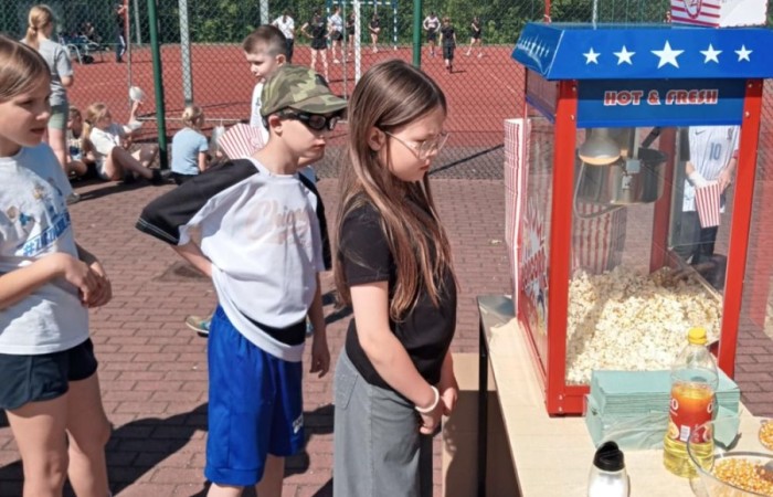 Tegoroczne obchody rozpoczęliśmy twórczo – od przygotowania plakatów „Mistrz zdrowia”. Po tej kreatywnej rozgrzewce przyszedł czas na sportowe emocje. Uroczyste otwarcie było tylko wstępem do licznych atrakcji, które czekały na dzieci na stadionie. Dzięki zaangażowaniu pana Piotra Borysewicza i sportowców z KS Polonia Pasłęk sekcji lekkoatletycznej, uczniowie mogli spróbować swoich sił w biegu przez płotki, rzucie piłeczką oraz torze przeszkód w stylu „Ninja Warrior”. Ogromną atrakcją była również wizyta strażaków z JRG 3 w Pasłęku, którzy zapewnili dzieciom wodno-pianową zabawę. Radość na twarzach uczestników mówiła sama za siebie. Na wszystkich zgłodniałych czekały pyszności, w tym słodka wata cukrowa, serwowana przez Panie z Koła Gospodyń Wiejskich w Borzynowie. Szczególne podziękowania kierujemy do niezastąpionych Rodziców – za wsparcie organizacyjne, opiekę podczas wydarzenia oraz przygotowanie dodatkowych atrakcji: plenerowego studia malowania twarzy i tatuaży. Na zakończenie nikt nie wyszedł z pustymi rękami – niezależnie od wyników konkursów każdy uczeń otrzymał drobny upominek i medal. To wyjątkowe święto pełne radości i zabawy już za nami, więc zaczynamy odliczanie do kolejnego Dnia Dziecka!