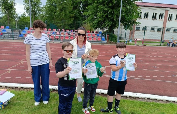 Tegoroczne obchody rozpoczęliśmy twórczo – od przygotowania plakatów „Mistrz zdrowia”. Po tej kreatywnej rozgrzewce przyszedł czas na sportowe emocje. Uroczyste otwarcie było tylko wstępem do licznych atrakcji, które czekały na dzieci na stadionie. Dzięki zaangażowaniu pana Piotra Borysewicza i sportowców z KS Polonia Pasłęk sekcji lekkoatletycznej, uczniowie mogli spróbować swoich sił w biegu przez płotki, rzucie piłeczką oraz torze przeszkód w stylu „Ninja Warrior”. Ogromną atrakcją była również wizyta strażaków z JRG 3 w Pasłęku, którzy zapewnili dzieciom wodno-pianową zabawę. Radość na twarzach uczestników mówiła sama za siebie. Na wszystkich zgłodniałych czekały pyszności, w tym słodka wata cukrowa, serwowana przez Panie z Koła Gospodyń Wiejskich w Borzynowie. Szczególne podziękowania kierujemy do niezastąpionych Rodziców – za wsparcie organizacyjne, opiekę podczas wydarzenia oraz przygotowanie dodatkowych atrakcji: plenerowego studia malowania twarzy i tatuaży. Na zakończenie nikt nie wyszedł z pustymi rękami – niezależnie od wyników konkursów każdy uczeń otrzymał drobny upominek i medal. To wyjątkowe święto pełne radości i zabawy już za nami, więc zaczynamy odliczanie do kolejnego Dnia Dziecka!