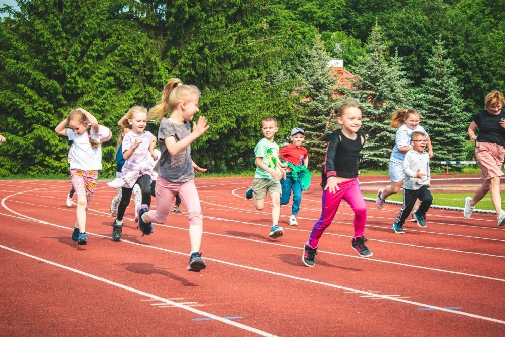 2 czerwca nasze przedszkolaki obchodziły Dzień Dziecka wyjątkowo aktywnie!
Na stadionie miejskim, obok różnych zabaw sportowych ,wzięły udział w XI edycji Ogólnopolskiego Maratonu Przedszkolaków „Sprintem do maratonu”.
Zaczęliśmy od przywitania przez p. Dyrektor oraz życzeń z okazji Dnia Dziecka, a później zaczął się –wielki bieg! Każde dziecko z ogromnym zaangażowaniem pokonało wyznaczony dystans, a na mecie czekała na wszystkich zasłużona nagroda – medal, który każdemu osobiście wręczyła p. Wicedyrektor
Po sportowych emocjach przyszedł czas na chwilę wytchnienia i uzupełnienie spalonych kalorii .
Jesteśmy dumne, że nasze przedszkolaki pokonały łącznie aż  3,8 km !
To był niezapomniany dzień pełen ruchu, radości i wspólnej zabawy.