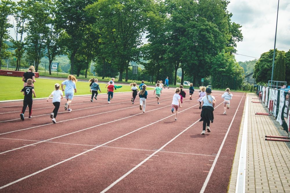 2 czerwca nasze przedszkolaki obchodziły Dzień Dziecka wyjątkowo aktywnie!
Na stadionie miejskim, obok różnych zabaw sportowych ,wzięły udział w XI edycji Ogólnopolskiego Maratonu Przedszkolaków „Sprintem do maratonu”.
Zaczęliśmy od przywitania przez p. Dyrektor oraz życzeń z okazji Dnia Dziecka, a później zaczął się –wielki bieg! Każde dziecko z ogromnym zaangażowaniem pokonało wyznaczony dystans, a na mecie czekała na wszystkich zasłużona nagroda – medal, który każdemu osobiście wręczyła p. Wicedyrektor
Po sportowych emocjach przyszedł czas na chwilę wytchnienia i uzupełnienie spalonych kalorii .
Jesteśmy dumne, że nasze przedszkolaki pokonały łącznie aż  3,8 km !
To był niezapomniany dzień pełen ruchu, radości i wspólnej zabawy.