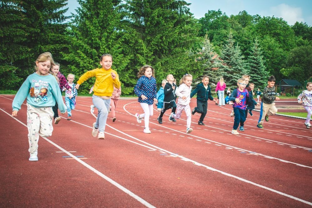 2 czerwca nasze przedszkolaki obchodziły Dzień Dziecka wyjątkowo aktywnie!
Na stadionie miejskim, obok różnych zabaw sportowych ,wzięły udział w XI edycji Ogólnopolskiego Maratonu Przedszkolaków „Sprintem do maratonu”.
Zaczęliśmy od przywitania przez p. Dyrektor oraz życzeń z okazji Dnia Dziecka, a później zaczął się –wielki bieg! Każde dziecko z ogromnym zaangażowaniem pokonało wyznaczony dystans, a na mecie czekała na wszystkich zasłużona nagroda – medal, który każdemu osobiście wręczyła p. Wicedyrektor
Po sportowych emocjach przyszedł czas na chwilę wytchnienia i uzupełnienie spalonych kalorii .
Jesteśmy dumne, że nasze przedszkolaki pokonały łącznie aż  3,8 km !
To był niezapomniany dzień pełen ruchu, radości i wspólnej zabawy.