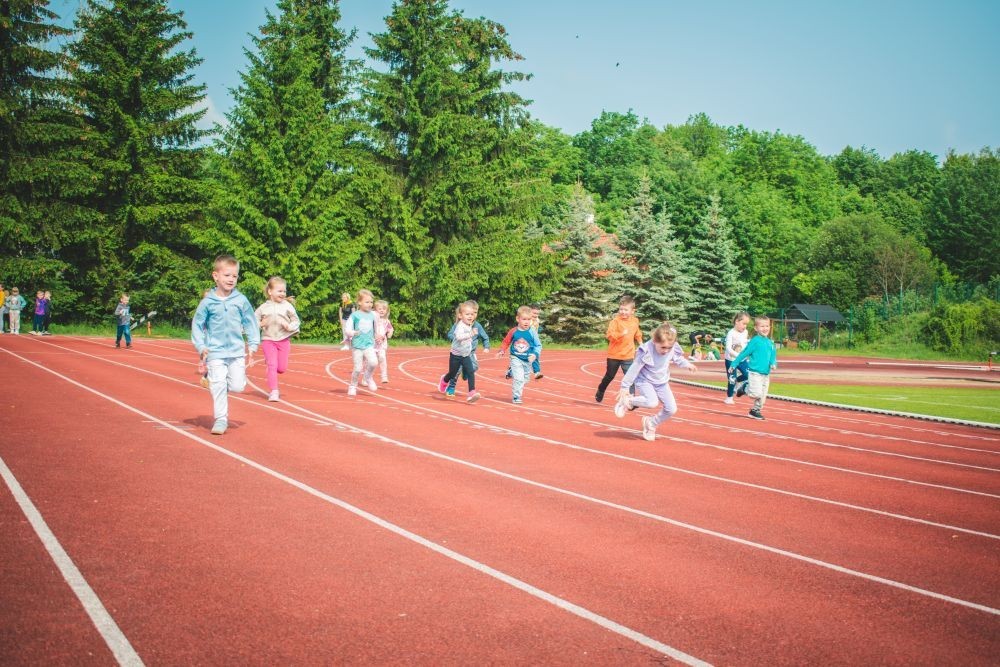 2 czerwca nasze przedszkolaki obchodziły Dzień Dziecka wyjątkowo aktywnie!
Na stadionie miejskim, obok różnych zabaw sportowych ,wzięły udział w XI edycji Ogólnopolskiego Maratonu Przedszkolaków „Sprintem do maratonu”.
Zaczęliśmy od przywitania przez p. Dyrektor oraz życzeń z okazji Dnia Dziecka, a później zaczął się –wielki bieg! Każde dziecko z ogromnym zaangażowaniem pokonało wyznaczony dystans, a na mecie czekała na wszystkich zasłużona nagroda – medal, który każdemu osobiście wręczyła p. Wicedyrektor
Po sportowych emocjach przyszedł czas na chwilę wytchnienia i uzupełnienie spalonych kalorii .
Jesteśmy dumne, że nasze przedszkolaki pokonały łącznie aż  3,8 km !
To był niezapomniany dzień pełen ruchu, radości i wspólnej zabawy.