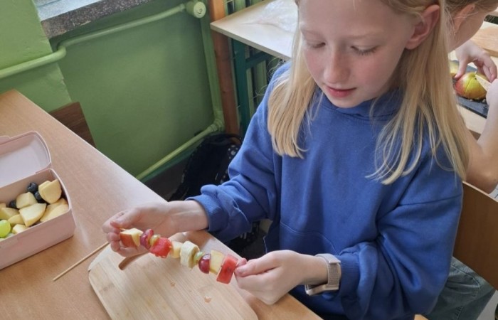 W klasie 2a zrobiło się kolorowo, zdrowo i pysznie. Uczniowie z ogromnym zaangażowaniem przygotowywali owocowe szaszłyki, które zachwycały nie tylko smakiem, ale też wyglądem. Na stołach królowały ulubione owoce dzieci: truskawki, winogrona, banany, kiwi, jabłka i wiele innych. Każdy samodzielnie kroił owoce i tworzył własne, kreatywne kompozycje. To była nie tylko smakowita zabawa, ale również świetna okazja do rozmów o zdrowym odżywianiu oraz nauki współpracy.