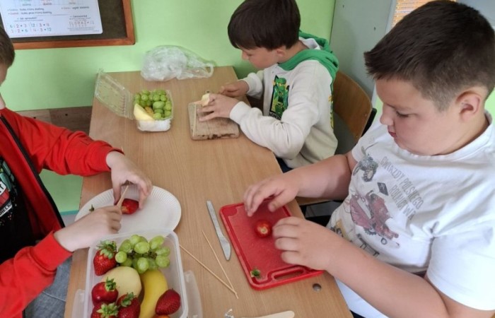 W klasie 2a zrobiło się kolorowo, zdrowo i pysznie. Uczniowie z ogromnym zaangażowaniem przygotowywali owocowe szaszłyki, które zachwycały nie tylko smakiem, ale też wyglądem. Na stołach królowały ulubione owoce dzieci: truskawki, winogrona, banany, kiwi, jabłka i wiele innych. Każdy samodzielnie kroił owoce i tworzył własne, kreatywne kompozycje. To była nie tylko smakowita zabawa, ale również świetna okazja do rozmów o zdrowym odżywianiu oraz nauki współpracy.