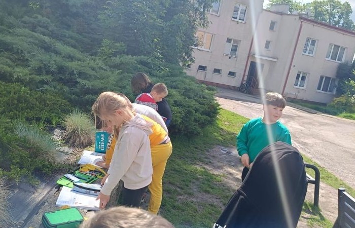 Klasa 1a ruszyła dziś z miarkami krawieckimi na szkolny plac, żeby sprawdzić, ile mierzy… brama, śmietnik i krawężnik. Dzięki praktycznym zajęciom dzieci nie tylko utrwaliły pojęcia związane z długością, ale też świetnie się bawiły mierząc wszystko, co tylko dało się zmierzyć. Takie lekcje to prawdziwa frajda – nauka przez działanie i odkrywanie świata wokół nas.