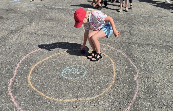 Dziś uczniowie klasy 2b wybrali się na plac przed szkołę, gdzie połączyli przyjemne z pożytecznym. Podczas zabawy w rzuty woreczkiem do celu dzieci nie tylko świetnie się bawiły, ale również ćwiczyły swoją sprawność rachunkową – dodając zdobyte przez grupy punkty.  Radość, ruch i nauka w jednym – właśnie tak lubimy się uczyć.