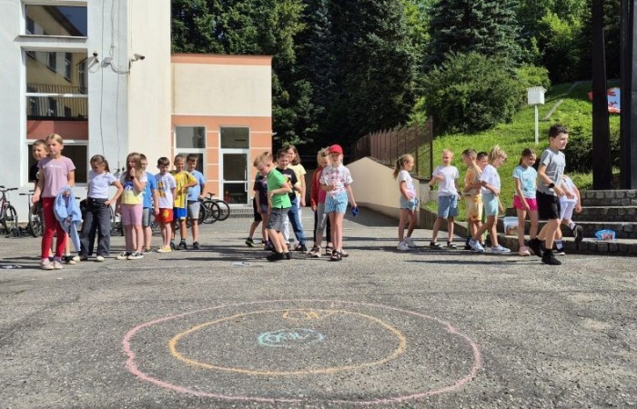 Dziś uczniowie klasy 2b wybrali się na plac przed szkołę, gdzie połączyli przyjemne z pożytecznym. Podczas zabawy w rzuty woreczkiem do celu dzieci nie tylko świetnie się bawiły, ale również ćwiczyły swoją sprawność rachunkową – dodając zdobyte przez grupy punkty.  Radość, ruch i nauka w jednym – właśnie tak lubimy się uczyć.