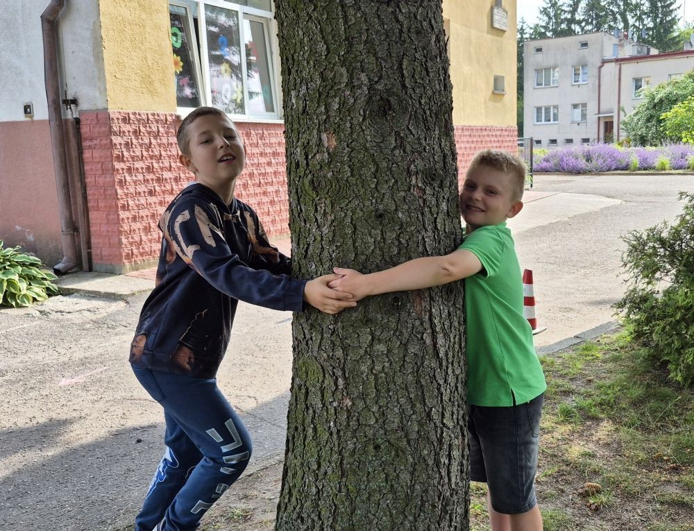 W ramach projektu S.Z.U.M. nasi najmłodsi uczniowie z klas 1-3 wzięli udział w wyjątkowej zabawie edukacyjnej – podchodach ekologicznych. Na terenie szkoły czekały na nich liczne zadania, które nie tylko dostarczyły mnóstwo radości, ale również uczyły, jak dbać o naszą planetę. Dzieci m.in.: rozwiązywały zagadki przyrodnicze, przytulały drzewa, poszukiwały ukrytych figurek zwierząt, wspólnie śpiewały piosenkę o Ziemi, zapisywały ekologiczne hasła – jak pomagać planecie, pokonywały tor przeszkód z ekologicznym przesłaniem. Było radośnie, aktywnie i bardzo zielono.