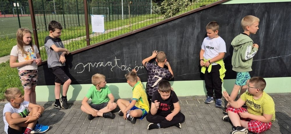 W ramach projektu S.Z.U.M. nasi najmłodsi uczniowie z klas 1-3 wzięli udział w wyjątkowej zabawie edukacyjnej – podchodach ekologicznych. Na terenie szkoły czekały na nich liczne zadania, które nie tylko dostarczyły mnóstwo radości, ale również uczyły, jak dbać o naszą planetę. Dzieci m.in.: rozwiązywały zagadki przyrodnicze, przytulały drzewa, poszukiwały ukrytych figurek zwierząt, wspólnie śpiewały piosenkę o Ziemi, zapisywały ekologiczne hasła – jak pomagać planecie, pokonywały tor przeszkód z ekologicznym przesłaniem. Było radośnie, aktywnie i bardzo zielono.