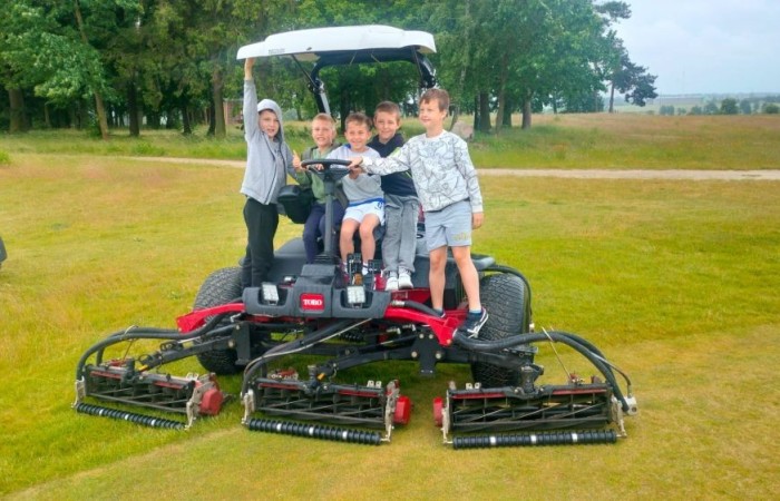 Choć pogoda nie do końca dopisała, uczniowie klasy 2b spędzili niezwykle ciekawy dzień w Sand Valley Golf Resort w Pasłęku. Dzieci miały okazję: dowiedzieć się, na czym polega gra w golfa, obejrzeć profesjonalny sprzęt wykorzystywany w tym sporcie, przejechać się meleksem po rozległym terenie, spróbować pysznych frytek i orzeźwiającej lemoniady serwowanych w tutejszej restauracji. Na zakończenie każdy uczestnik otrzymał pamiątkowy medal, piłeczkę golfową i drobne upominki. Niestety, z powodu deszczu nie udało się przeprowadzić treningu uderzeń piłeczki… ale kto wie – może następnym razem pogoda będzie łaskawsza.