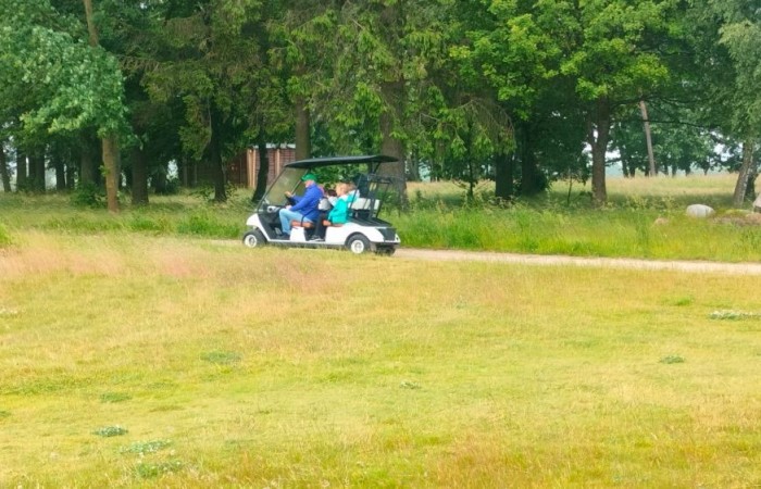 Choć pogoda nie do końca dopisała, uczniowie klasy 2b spędzili niezwykle ciekawy dzień w Sand Valley Golf Resort w Pasłęku. Dzieci miały okazję: dowiedzieć się, na czym polega gra w golfa, obejrzeć profesjonalny sprzęt wykorzystywany w tym sporcie, przejechać się meleksem po rozległym terenie, spróbować pysznych frytek i orzeźwiającej lemoniady serwowanych w tutejszej restauracji. Na zakończenie każdy uczestnik otrzymał pamiątkowy medal, piłeczkę golfową i drobne upominki. Niestety, z powodu deszczu nie udało się przeprowadzić treningu uderzeń piłeczki… ale kto wie – może następnym razem pogoda będzie łaskawsza.