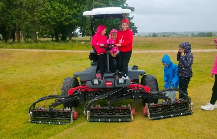 Choć pogoda nie do końca dopisała, uczniowie klasy 2b spędzili niezwykle ciekawy dzień w Sand Valley Golf Resort w Pasłęku. Dzieci miały okazję: dowiedzieć się, na czym polega gra w golfa, obejrzeć profesjonalny sprzęt wykorzystywany w tym sporcie, przejechać się meleksem po rozległym terenie, spróbować pysznych frytek i orzeźwiającej lemoniady serwowanych w tutejszej restauracji. Na zakończenie każdy uczestnik otrzymał pamiątkowy medal, piłeczkę golfową i drobne upominki. Niestety, z powodu deszczu nie udało się przeprowadzić treningu uderzeń piłeczki… ale kto wie – może następnym razem pogoda będzie łaskawsza.