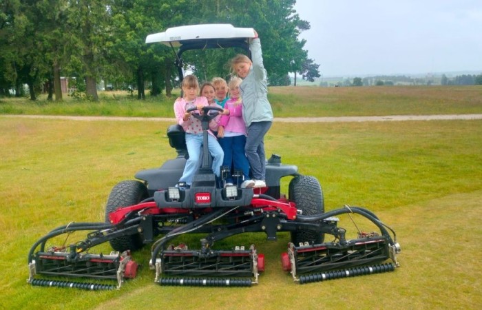 Choć pogoda nie do końca dopisała, uczniowie klasy 2b spędzili niezwykle ciekawy dzień w Sand Valley Golf Resort w Pasłęku. Dzieci miały okazję: dowiedzieć się, na czym polega gra w golfa, obejrzeć profesjonalny sprzęt wykorzystywany w tym sporcie, przejechać się meleksem po rozległym terenie, spróbować pysznych frytek i orzeźwiającej lemoniady serwowanych w tutejszej restauracji. Na zakończenie każdy uczestnik otrzymał pamiątkowy medal, piłeczkę golfową i drobne upominki. Niestety, z powodu deszczu nie udało się przeprowadzić treningu uderzeń piłeczki… ale kto wie – może następnym razem pogoda będzie łaskawsza.