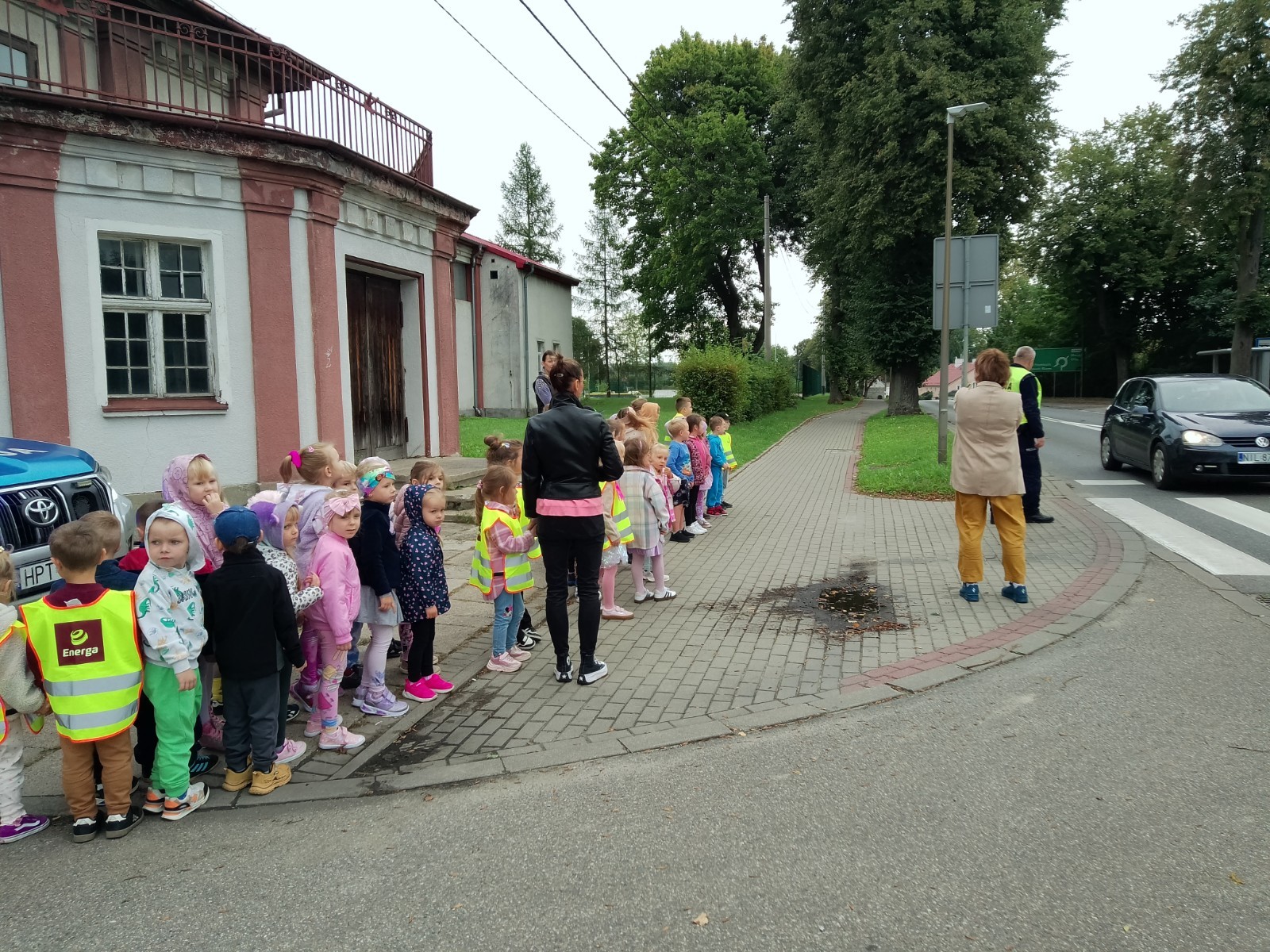 Dzieci z grup starszych Sówki, Leśne skrzaty oraz Biedronki odwiedzili funkcjonariusze policji drogowej , którzy przeprowadzili zajęcia edukacyjne na temat bezpieczeństwa w ruchu ulicznym. Wydarzenie odbyło się w ramach zajęć ,,Moja droga do przedszkola”, której celem jest kształtowanie prawidłowych nawyków i świadomości wśród najmłodszych uczestników ruchu drogowego. Policjanci opowiedzieli przedszkolakom o zasadach bezpiecznego przechodzenia przez jezdnię, znaczeniu znaków drogowych. Dzieci dowiedziały się również, dlaczego ważne jest noszenie odblasków, zwłaszcza jesienią i zimą, gdy wcześniej zapada zmrok.                                
Takie spotkania są bardzo ważne. Dzieci w tym wieku chłoną wiedzę jak gąbka.                  Warto więc już teraz uczyć je zasad, które mogą uratować życie. Przedszkolaki pożegnały policjanta gromkimi brawami i obiecały zawsze pamiętać o zasadach bezpieczeństwa.
Spotkanie z policjantem było nie tylko cenną lekcją, ale też okazją do wzbudzenia w dzieciach zaufania do funkcjonariuszy. To ważny krok w budowaniu poczucia bezpieczeństwa od najmłodszych lat.
