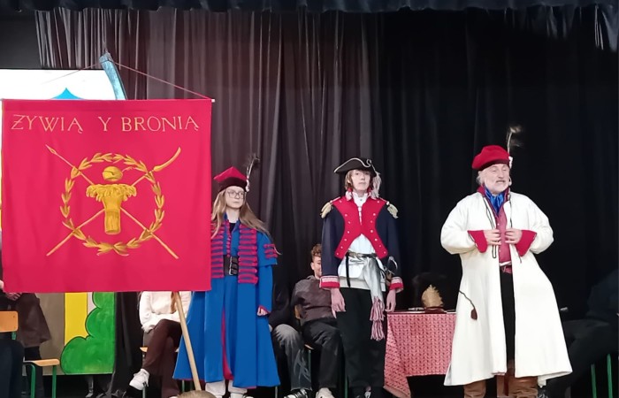 Każdego roku uczniowie naszej szkoły mają niepowtarzalną okazję wziąć udział w wyjątkowym wydarzeniu edukacyjnym - ŻYWEJ LEKCJI HISTORII, prowadzonej przez grupę rekonstrukcyjną Chorągiew Komturstwa Gniewskiego. To spotkanie, które na długo pozostaje w pamięci uczestników, łącząc wiedzę historyczną z emocjami, ruchem i bezpośrednim kontaktem z przeszłością.
W tym roku tematyka spotkań została zrealizowana na dwóch poziomach wiekowych:
Klasy 4-6: Świat starożytnych Greków i Rzymian
Uczniowie klas młodszych przenieśli się do czasów starożytności - epoki potężnych cywilizacji, mitologii, igrzysk olimpijskich i legionów rzymskich. Dzięki strojom z epoki, realistycznym rekwizytom i barwnym opowieściom rekonstruktorów, dzieci mogły poczuć atmosferę antycznego świata. Dowiedzieli się, jak wyglądało życie codzienne Greków i Rzymian, jakie były zwyczaje wojenne, a nawet jak wyglądały ćwiczenia wojskowe legionistów. Zajęcia - prowadzone w formie interaktywnej - dały uczniom możliwość przymierzenia elementów uzbrojenia oraz wzięcia udziału w krótkich pokazach.
Klasy 7-8: Długi wiek XIX
Starsze klasy uczestniczyły w lekcji poświęconej Długiemu wiekowi XIX, czyli okresowi, który ukształtował współczesny świat. Rekonstruktorzy przybliżyli wydarzenia związane z rewolucjami, walką o niepodległość, przemianami społecznymi i narodzinami nowoczesnych idei. Szczególną uwagę poświęcono wydarzeniom ważnym dla Polski - rozbiorom, powstaniom narodowym i postaciom kluczowym dla naszej historii. Uczniowie mogli zobaczyć repliki broni, a także stroje z XIX wieku. Dla wielu była to okazja do poznania historii w sposób bardziej angażujący niż podręcznik - przez opowieści, prezentacje multimedialne i inscenizacje.
Żywa lekcja historii to nie tylko atrakcja, ale przede wszystkim cenna forma nauki. Bezpośredni kontakt z pasjonatami historii oraz aktywne uczestnictwo w przedsięwzięciu sprawia, że uczniowie lepiej zapamiętują materiał, rozbudzają swoją ciekawość i rozwijają szacunek do dziedzictwa kulturowego.