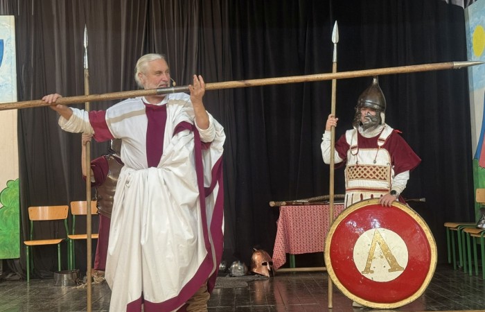 Każdego roku uczniowie naszej szkoły mają niepowtarzalną okazję wziąć udział w wyjątkowym wydarzeniu edukacyjnym - ŻYWEJ LEKCJI HISTORII, prowadzonej przez grupę rekonstrukcyjną Chorągiew Komturstwa Gniewskiego. To spotkanie, które na długo pozostaje w pamięci uczestników, łącząc wiedzę historyczną z emocjami, ruchem i bezpośrednim kontaktem z przeszłością.
W tym roku tematyka spotkań została zrealizowana na dwóch poziomach wiekowych:
Klasy 4-6: Świat starożytnych Greków i Rzymian
Uczniowie klas młodszych przenieśli się do czasów starożytności - epoki potężnych cywilizacji, mitologii, igrzysk olimpijskich i legionów rzymskich. Dzięki strojom z epoki, realistycznym rekwizytom i barwnym opowieściom rekonstruktorów, dzieci mogły poczuć atmosferę antycznego świata. Dowiedzieli się, jak wyglądało życie codzienne Greków i Rzymian, jakie były zwyczaje wojenne, a nawet jak wyglądały ćwiczenia wojskowe legionistów. Zajęcia - prowadzone w formie interaktywnej - dały uczniom możliwość przymierzenia elementów uzbrojenia oraz wzięcia udziału w krótkich pokazach.
Klasy 7-8: Długi wiek XIX
Starsze klasy uczestniczyły w lekcji poświęconej Długiemu wiekowi XIX, czyli okresowi, który ukształtował współczesny świat. Rekonstruktorzy przybliżyli wydarzenia związane z rewolucjami, walką o niepodległość, przemianami społecznymi i narodzinami nowoczesnych idei. Szczególną uwagę poświęcono wydarzeniom ważnym dla Polski - rozbiorom, powstaniom narodowym i postaciom kluczowym dla naszej historii. Uczniowie mogli zobaczyć repliki broni, a także stroje z XIX wieku. Dla wielu była to okazja do poznania historii w sposób bardziej angażujący niż podręcznik - przez opowieści, prezentacje multimedialne i inscenizacje.
Żywa lekcja historii to nie tylko atrakcja, ale przede wszystkim cenna forma nauki. Bezpośredni kontakt z pasjonatami historii oraz aktywne uczestnictwo w przedsięwzięciu sprawia, że uczniowie lepiej zapamiętują materiał, rozbudzają swoją ciekawość i rozwijają szacunek do dziedzictwa kulturowego.