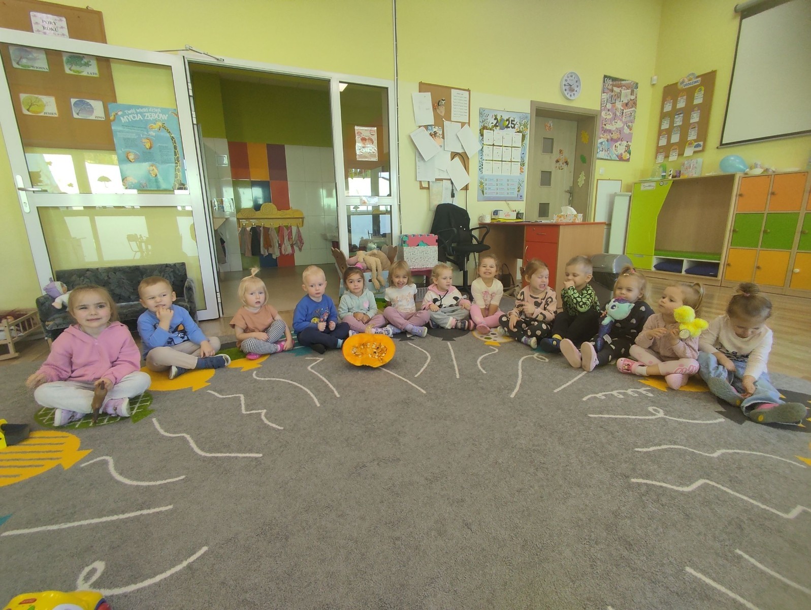 31 października nasze przedszkole zamieniło się w prawdziwą dyniową krainę! W salach królował kolor pomarańczowy, a wszędzie można było zobaczyć uśmiechnięte buzie dzieci i  dynie w różnych kształtach i rozmiarach.Przedszkolaki chętnie brały udział w zabawach muzyczno-ruchowych oraz zajęciach plastycznych z dynią w roli głównej.
Dzieci dowiedziały się, że dynia to nie tylko piękna ozdoba jesieni, ale również zdrowe i smaczne warzywo, z którego można przygotować wiele pysznych potraw.Na zakończenie dnia dzieci otrzymały dyniowe medale oraz pamiątkowe dyplomy,świadczące o ich udziale i zaangażowaniu w obchody tego święta.
To był dzień pełen radości, kolorów ,niezapomnianych wrażeń i jesiennej magii.
