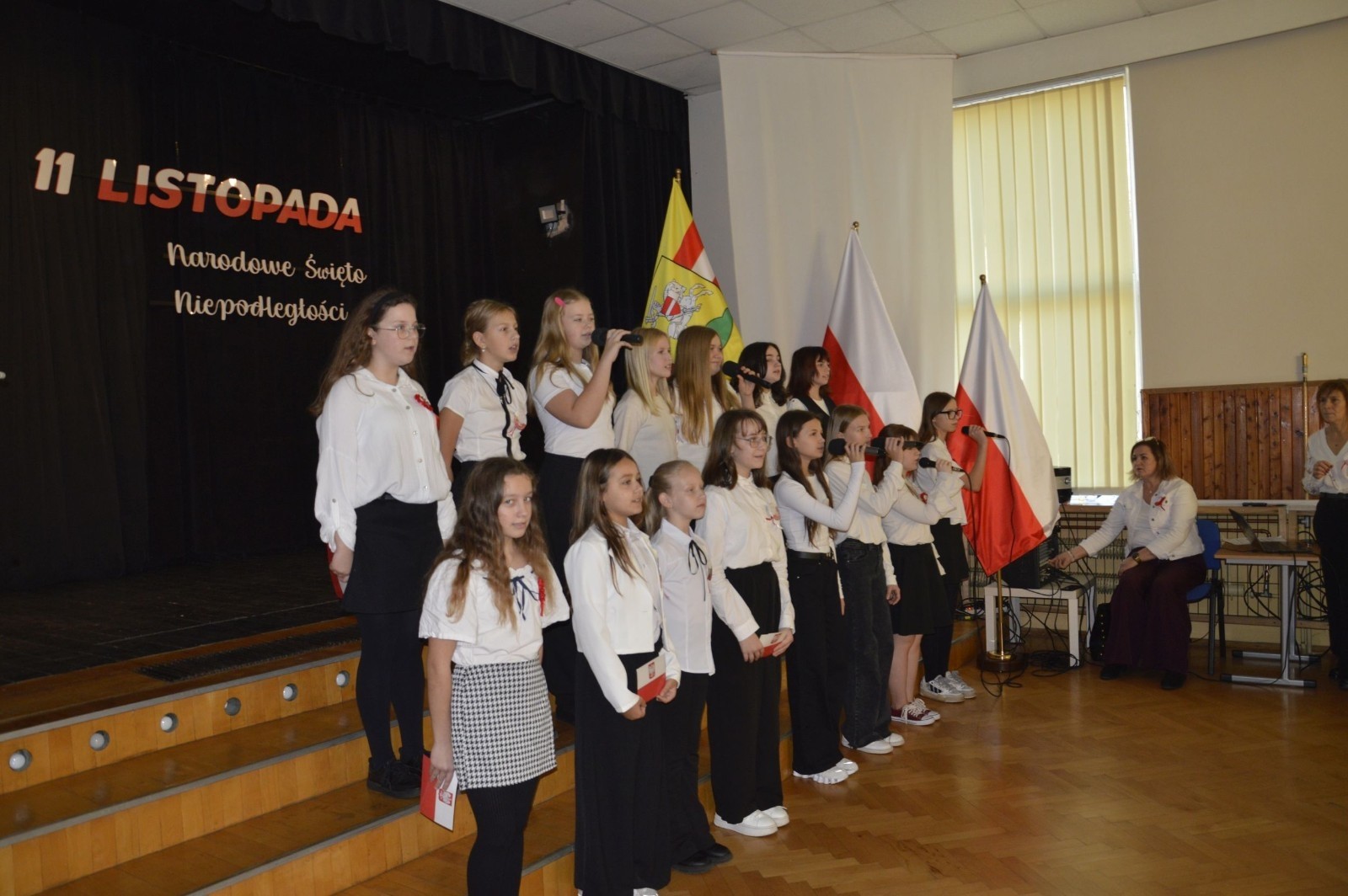 Zbliża się bardzo ważny dzień dla każdego Polaka – 11 Listopada. Nasza szkoła już dziś postanowiła uczcić ten dzień - odbyła się uroczystość z okazji Narodowego Dnia Niepodległości. Był to wyjątkowy czas, podczas którego cała społeczność szkolna mogła wspólnie uczcić jedno z najważniejszych świąt państwowych w Polsce.
Głównym punktem programu był występ uczniów klas szóstych, którzy pod kierunkiem wychowawców, przygotowali wzruszające przedstawienie o tematyce patriotycznej. Młodzi artyści z wielkim zaangażowaniem zaprezentowali najważniejsze wydarzenia, przypominając wszystkim o drodze Polski do wolności oraz o bohaterach narodowych.
Uroczystość uświetnił również występ zespołu wokalnego Forte, prowadzonego przez panią Iwonę Matukiewicz. 
Ważnym momentem wydarzenia było wspólne odśpiewanie hymnu narodowego oraz innych pieśni patriotycznych. Ta chwila połączyła wszystkich uczestników w poczuciu wspólnoty i dumy z bycia Polakami.
Serdecznie dziękujemy wszystkim uczniom, nauczycielom i gościom za udział w uroczystości oraz zaangażowanie w pielęgnowanie pamięci o historii naszego kraju.
