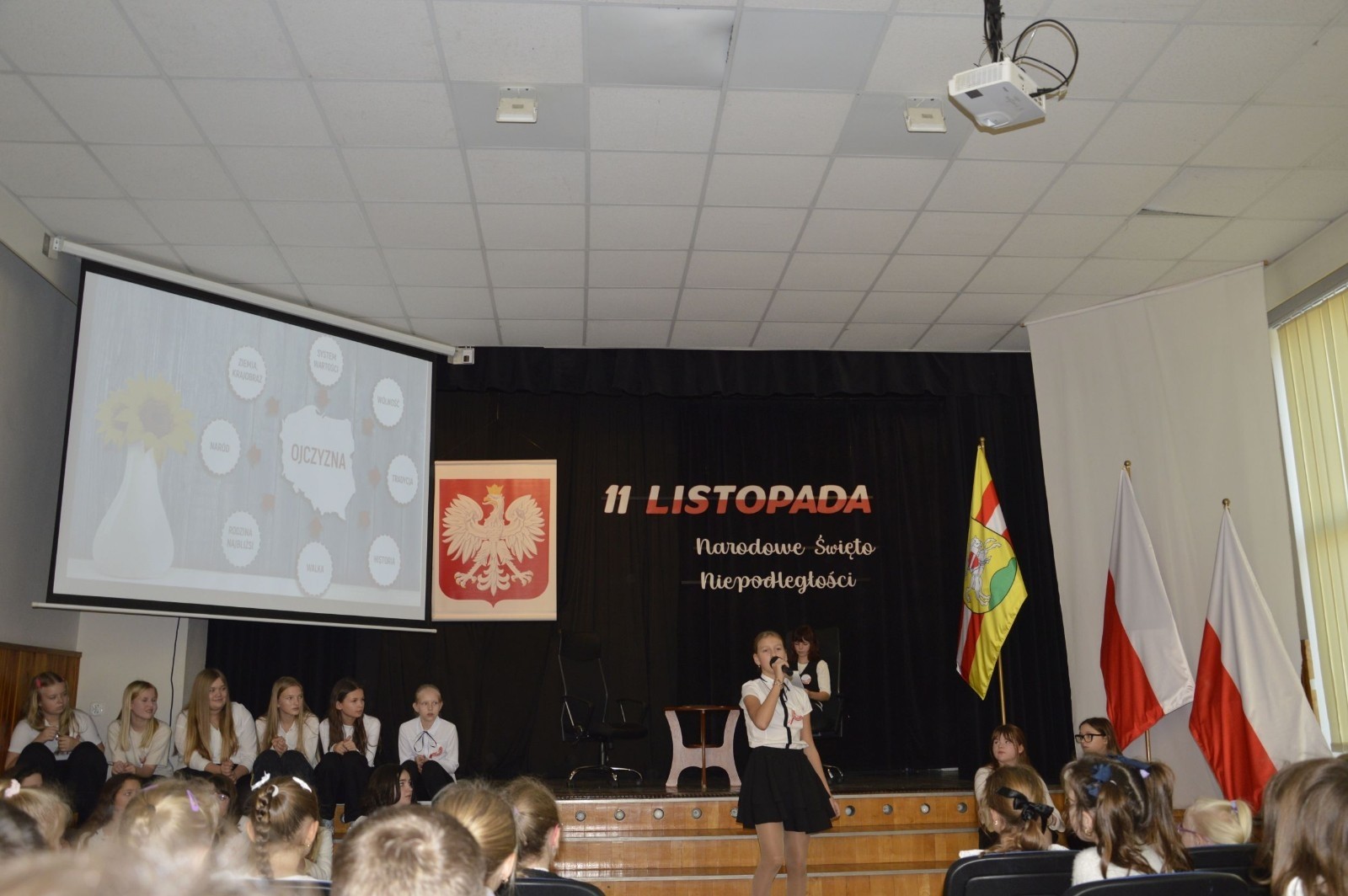 Zbliża się bardzo ważny dzień dla każdego Polaka – 11 Listopada. Nasza szkoła już dziś postanowiła uczcić ten dzień - odbyła się uroczystość z okazji Narodowego Dnia Niepodległości. Był to wyjątkowy czas, podczas którego cała społeczność szkolna mogła wspólnie uczcić jedno z najważniejszych świąt państwowych w Polsce.
Głównym punktem programu był występ uczniów klas szóstych, którzy pod kierunkiem wychowawców, przygotowali wzruszające przedstawienie o tematyce patriotycznej. Młodzi artyści z wielkim zaangażowaniem zaprezentowali najważniejsze wydarzenia, przypominając wszystkim o drodze Polski do wolności oraz o bohaterach narodowych.
Uroczystość uświetnił również występ zespołu wokalnego Forte, prowadzonego przez panią Iwonę Matukiewicz. 
Ważnym momentem wydarzenia było wspólne odśpiewanie hymnu narodowego oraz innych pieśni patriotycznych. Ta chwila połączyła wszystkich uczestników w poczuciu wspólnoty i dumy z bycia Polakami.
Serdecznie dziękujemy wszystkim uczniom, nauczycielom i gościom za udział w uroczystości oraz zaangażowanie w pielęgnowanie pamięci o historii naszego kraju.
