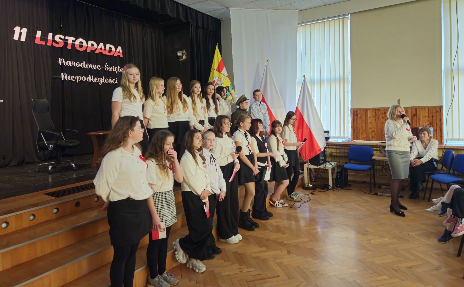 Zbliża się bardzo ważny dzień dla każdego Polaka – 11 Listopada. Nasza szkoła już dziś postanowiła uczcić ten dzień - odbyła się uroczystość z okazji Narodowego Dnia Niepodległości. Był to wyjątkowy czas, podczas którego cała społeczność szkolna mogła wspólnie uczcić jedno z najważniejszych świąt państwowych w Polsce.
Głównym punktem programu był występ uczniów klas szóstych, którzy pod kierunkiem wychowawców, przygotowali wzruszające przedstawienie o tematyce patriotycznej. Młodzi artyści z wielkim zaangażowaniem zaprezentowali najważniejsze wydarzenia, przypominając wszystkim o drodze Polski do wolności oraz o bohaterach narodowych.
Uroczystość uświetnił również występ zespołu wokalnego Forte, prowadzonego przez panią Iwonę Matukiewicz. 
Ważnym momentem wydarzenia było wspólne odśpiewanie hymnu narodowego oraz innych pieśni patriotycznych. Ta chwila połączyła wszystkich uczestników w poczuciu wspólnoty i dumy z bycia Polakami.
Serdecznie dziękujemy wszystkim uczniom, nauczycielom i gościom za udział w uroczystości oraz zaangażowanie w pielęgnowanie pamięci o historii naszego kraju.
