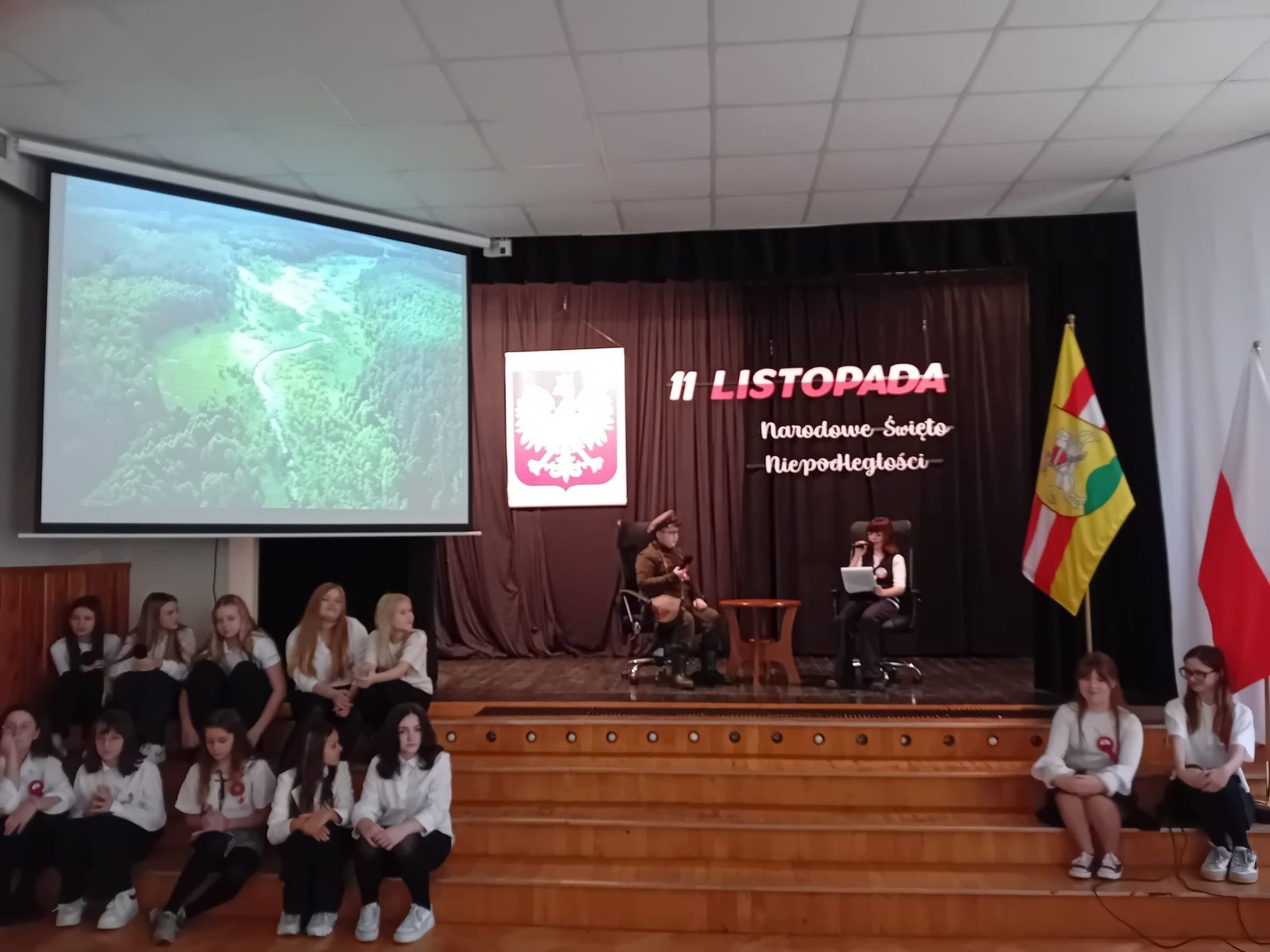 Zbliża się bardzo ważny dzień dla każdego Polaka – 11 Listopada. Nasza szkoła już dziś postanowiła uczcić ten dzień - odbyła się uroczystość z okazji Narodowego Dnia Niepodległości. Był to wyjątkowy czas, podczas którego cała społeczność szkolna mogła wspólnie uczcić jedno z najważniejszych świąt państwowych w Polsce.
Głównym punktem programu był występ uczniów klas szóstych, którzy pod kierunkiem wychowawców, przygotowali wzruszające przedstawienie o tematyce patriotycznej. Młodzi artyści z wielkim zaangażowaniem zaprezentowali najważniejsze wydarzenia, przypominając wszystkim o drodze Polski do wolności oraz o bohaterach narodowych.
Uroczystość uświetnił również występ zespołu wokalnego Forte, prowadzonego przez panią Iwonę Matukiewicz. 
Ważnym momentem wydarzenia było wspólne odśpiewanie hymnu narodowego oraz innych pieśni patriotycznych. Ta chwila połączyła wszystkich uczestników w poczuciu wspólnoty i dumy z bycia Polakami.
Serdecznie dziękujemy wszystkim uczniom, nauczycielom i gościom za udział w uroczystości oraz zaangażowanie w pielęgnowanie pamięci o historii naszego kraju.
