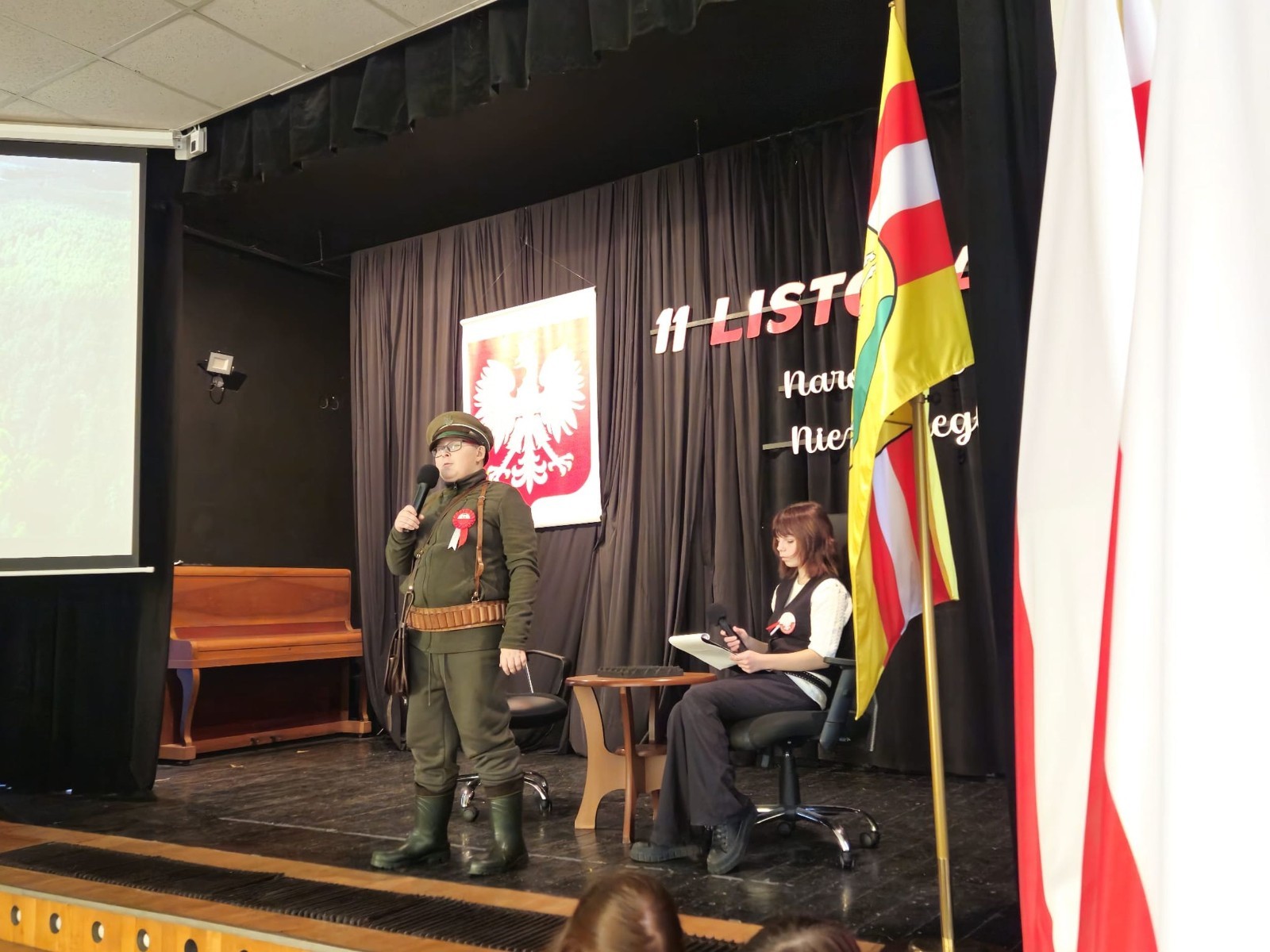 Zbliża się bardzo ważny dzień dla każdego Polaka – 11 Listopada. Nasza szkoła już dziś postanowiła uczcić ten dzień - odbyła się uroczystość z okazji Narodowego Dnia Niepodległości. Był to wyjątkowy czas, podczas którego cała społeczność szkolna mogła wspólnie uczcić jedno z najważniejszych świąt państwowych w Polsce.
Głównym punktem programu był występ uczniów klas szóstych, którzy pod kierunkiem wychowawców, przygotowali wzruszające przedstawienie o tematyce patriotycznej. Młodzi artyści z wielkim zaangażowaniem zaprezentowali najważniejsze wydarzenia, przypominając wszystkim o drodze Polski do wolności oraz o bohaterach narodowych.
Uroczystość uświetnił również występ zespołu wokalnego Forte, prowadzonego przez panią Iwonę Matukiewicz. 
Ważnym momentem wydarzenia było wspólne odśpiewanie hymnu narodowego oraz innych pieśni patriotycznych. Ta chwila połączyła wszystkich uczestników w poczuciu wspólnoty i dumy z bycia Polakami.
Serdecznie dziękujemy wszystkim uczniom, nauczycielom i gościom za udział w uroczystości oraz zaangażowanie w pielęgnowanie pamięci o historii naszego kraju.
