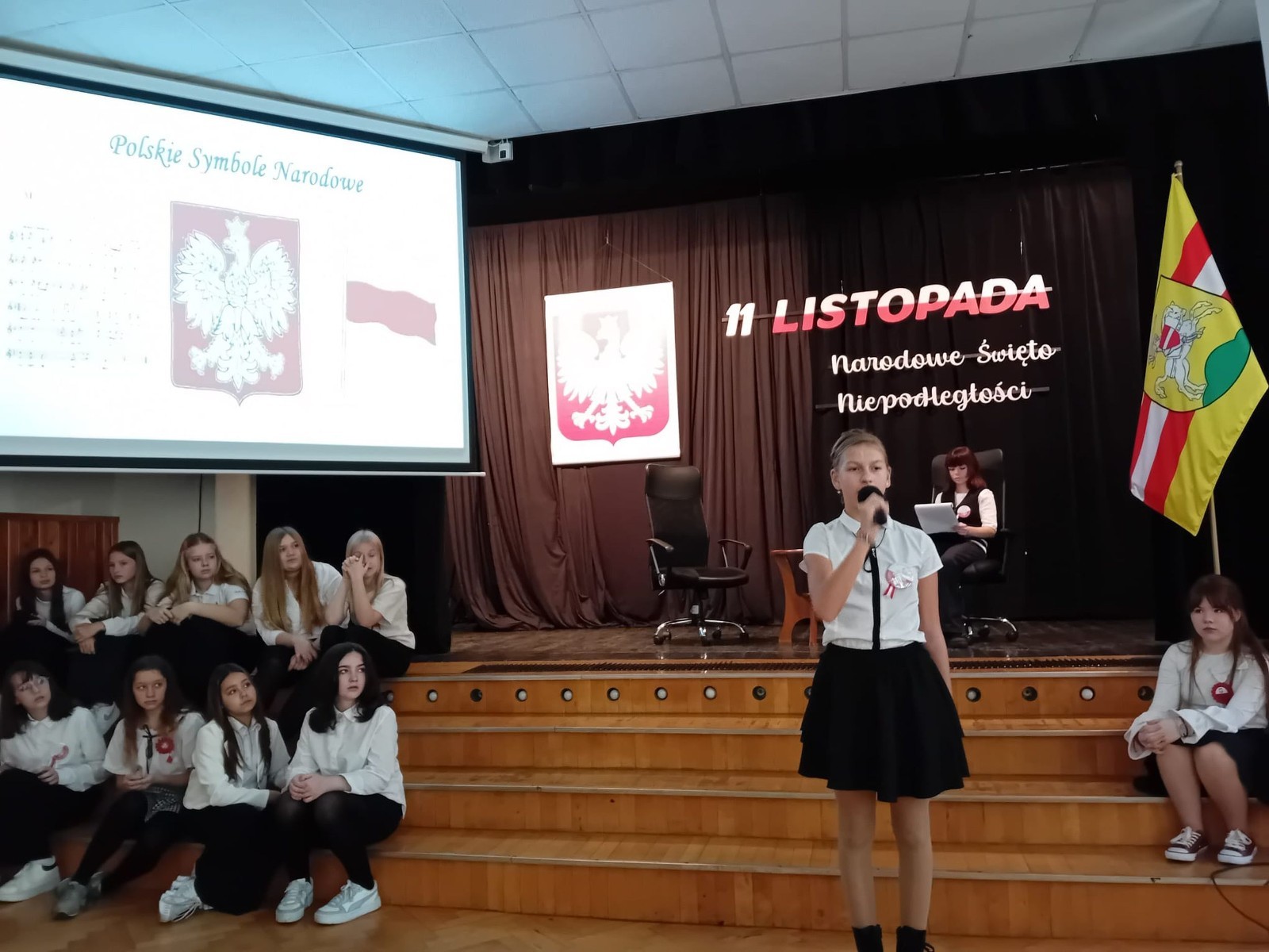 Zbliża się bardzo ważny dzień dla każdego Polaka – 11 Listopada. Nasza szkoła już dziś postanowiła uczcić ten dzień - odbyła się uroczystość z okazji Narodowego Dnia Niepodległości. Był to wyjątkowy czas, podczas którego cała społeczność szkolna mogła wspólnie uczcić jedno z najważniejszych świąt państwowych w Polsce.
Głównym punktem programu był występ uczniów klas szóstych, którzy pod kierunkiem wychowawców, przygotowali wzruszające przedstawienie o tematyce patriotycznej. Młodzi artyści z wielkim zaangażowaniem zaprezentowali najważniejsze wydarzenia, przypominając wszystkim o drodze Polski do wolności oraz o bohaterach narodowych.
Uroczystość uświetnił również występ zespołu wokalnego Forte, prowadzonego przez panią Iwonę Matukiewicz. 
Ważnym momentem wydarzenia było wspólne odśpiewanie hymnu narodowego oraz innych pieśni patriotycznych. Ta chwila połączyła wszystkich uczestników w poczuciu wspólnoty i dumy z bycia Polakami.
Serdecznie dziękujemy wszystkim uczniom, nauczycielom i gościom za udział w uroczystości oraz zaangażowanie w pielęgnowanie pamięci o historii naszego kraju.
