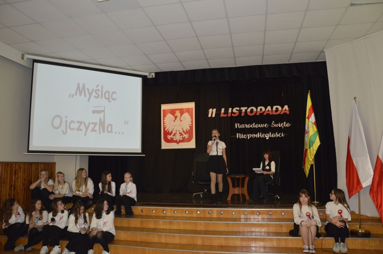 Zbliża się bardzo ważny dzień dla każdego Polaka – 11 Listopada. Nasza szkoła już dziś postanowiła uczcić ten dzień - odbyła się uroczystość z okazji Narodowego Dnia Niepodległości. Był to wyjątkowy czas, podczas którego cała społeczność szkolna mogła wspólnie uczcić jedno z najważniejszych świąt państwowych w Polsce.
Głównym punktem programu był występ uczniów klas szóstych, którzy pod kierunkiem wychowawców, przygotowali wzruszające przedstawienie o tematyce patriotycznej. Młodzi artyści z wielkim zaangażowaniem zaprezentowali najważniejsze wydarzenia, przypominając wszystkim o drodze Polski do wolności oraz o bohaterach narodowych.
Uroczystość uświetnił również występ zespołu wokalnego Forte, prowadzonego przez panią Iwonę Matukiewicz. 
Ważnym momentem wydarzenia było wspólne odśpiewanie hymnu narodowego oraz innych pieśni patriotycznych. Ta chwila połączyła wszystkich uczestników w poczuciu wspólnoty i dumy z bycia Polakami.
Serdecznie dziękujemy wszystkim uczniom, nauczycielom i gościom za udział w uroczystości oraz zaangażowanie w pielęgnowanie pamięci o historii naszego kraju.
