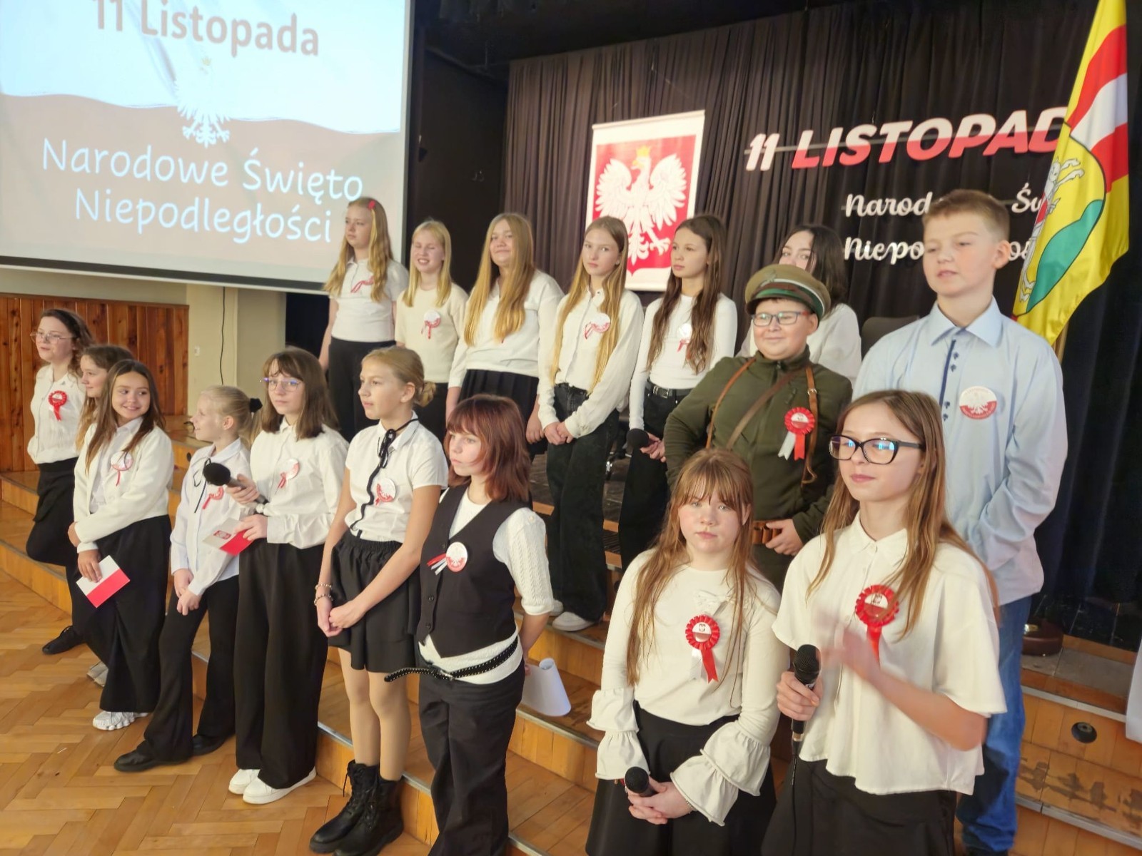 Zbliża się bardzo ważny dzień dla każdego Polaka – 11 Listopada. Nasza szkoła już dziś postanowiła uczcić ten dzień - odbyła się uroczystość z okazji Narodowego Dnia Niepodległości. Był to wyjątkowy czas, podczas którego cała społeczność szkolna mogła wspólnie uczcić jedno z najważniejszych świąt państwowych w Polsce.
Głównym punktem programu był występ uczniów klas szóstych, którzy pod kierunkiem wychowawców, przygotowali wzruszające przedstawienie o tematyce patriotycznej. Młodzi artyści z wielkim zaangażowaniem zaprezentowali najważniejsze wydarzenia, przypominając wszystkim o drodze Polski do wolności oraz o bohaterach narodowych.
Uroczystość uświetnił również występ zespołu wokalnego Forte, prowadzonego przez panią Iwonę Matukiewicz. 
Ważnym momentem wydarzenia było wspólne odśpiewanie hymnu narodowego oraz innych pieśni patriotycznych. Ta chwila połączyła wszystkich uczestników w poczuciu wspólnoty i dumy z bycia Polakami.
Serdecznie dziękujemy wszystkim uczniom, nauczycielom i gościom za udział w uroczystości oraz zaangażowanie w pielęgnowanie pamięci o historii naszego kraju.
