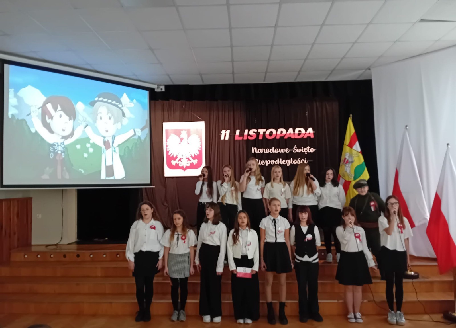 Zbliża się bardzo ważny dzień dla każdego Polaka – 11 Listopada. Nasza szkoła już dziś postanowiła uczcić ten dzień - odbyła się uroczystość z okazji Narodowego Dnia Niepodległości. Był to wyjątkowy czas, podczas którego cała społeczność szkolna mogła wspólnie uczcić jedno z najważniejszych świąt państwowych w Polsce.
Głównym punktem programu był występ uczniów klas szóstych, którzy pod kierunkiem wychowawców, przygotowali wzruszające przedstawienie o tematyce patriotycznej. Młodzi artyści z wielkim zaangażowaniem zaprezentowali najważniejsze wydarzenia, przypominając wszystkim o drodze Polski do wolności oraz o bohaterach narodowych.
Uroczystość uświetnił również występ zespołu wokalnego Forte, prowadzonego przez panią Iwonę Matukiewicz. 
Ważnym momentem wydarzenia było wspólne odśpiewanie hymnu narodowego oraz innych pieśni patriotycznych. Ta chwila połączyła wszystkich uczestników w poczuciu wspólnoty i dumy z bycia Polakami.
Serdecznie dziękujemy wszystkim uczniom, nauczycielom i gościom za udział w uroczystości oraz zaangażowanie w pielęgnowanie pamięci o historii naszego kraju.
