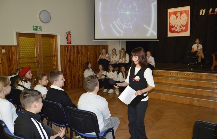 Zbliża się bardzo ważny dzień dla każdego Polaka – 11 Listopada. Nasza szkoła już dziś postanowiła uczcić ten dzień - odbyła się uroczystość z okazji Narodowego Dnia Niepodległości. Był to wyjątkowy czas, podczas którego cała społeczność szkolna mogła wspólnie uczcić jedno z najważniejszych świąt państwowych w Polsce.
Głównym punktem programu był występ uczniów klas szóstych, którzy pod kierunkiem wychowawców, przygotowali wzruszające przedstawienie o tematyce patriotycznej. Młodzi artyści z wielkim zaangażowaniem zaprezentowali najważniejsze wydarzenia, przypominając wszystkim o drodze Polski do wolności oraz o bohaterach narodowych.
Uroczystość uświetnił również występ zespołu wokalnego Forte, prowadzonego przez panią Iwonę Matukiewicz. 
Ważnym momentem wydarzenia było wspólne odśpiewanie hymnu narodowego oraz innych pieśni patriotycznych. Ta chwila połączyła wszystkich uczestników w poczuciu wspólnoty i dumy z bycia Polakami.
Serdecznie dziękujemy wszystkim uczniom, nauczycielom i gościom za udział w uroczystości oraz zaangażowanie w pielęgnowanie pamięci o historii naszego kraju.
