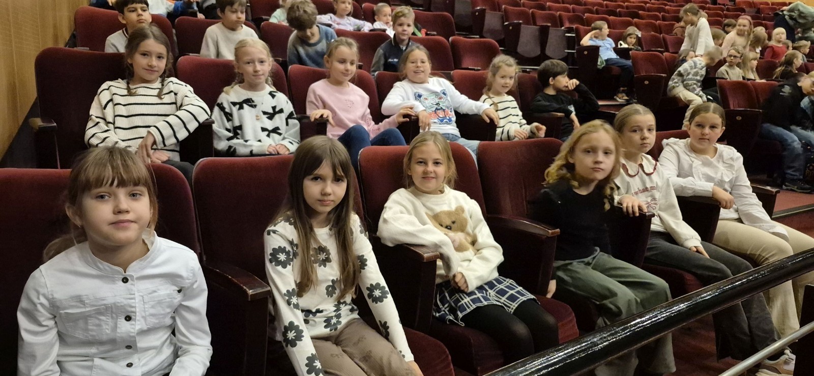 Uczniowie klas trzecich mieli dziś okazję uczestniczyć w wyjątkowym wydarzeniu artystycznym – odwiedzili Teatr im. Aleksandra Sewruka w Elblągu, gdzie obejrzeli spektakl „Dzieci z Bullerbyn”, przygotowany na podstawie uwielbianej przez kolejne pokolenia książki Astrid Lindgren.

Przedstawienie okazało się prawdziwą ucztą teatralną zarówno dla młodych widzów, jak i towarzyszących im nauczycieli. Twórcy spektaklu zadbali o to, by każda scena tętniła energią i kolorami. Na scenie pojawiło się wiele zabawnych historii i wzruszających momentów, które doskonale oddawały klimat klasycznej opowieści o przygodach dzieci z małej, szwedzkiej wioski.

W pamięci uczniów szczególnie zapisał się dynamiczny, pełen pozytywnej energii utwór muzyczny towarzyszący bohaterkom podczas powrotu z zakupów. Jego rytmiczna melodia wywołała szerokie uśmiechy na widowni i – jak przewidujemy – już wkrótce może stać się nieoficjalnym hitem szkolnych przerw.

Wizyta w teatrze była nie tylko okazją do świetnej zabawy, lecz także szansą na kontakt z kulturą w jej najpiękniejszym wydaniu. Uczniowie mogli zobaczyć, jak niezwykła potrafi być magia sceny i jak wiele emocji może przynieść profesjonalnie przygotowany spektakl. Dzisiejszy dzień z pewnością na długo pozostanie w pamięci naszych uczniów jako inspirujące spotkanie ze sztuką.
