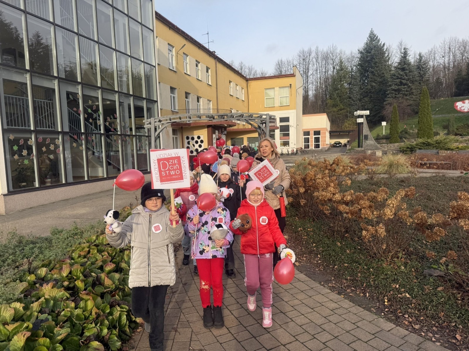 W środę 17.11.2025 nasza szkoła zorganizowała wyjątkowe wydarzenie, które było zaczątkiem podsumowania kampanii „Dzieciństwo bez Przemocy”. Dzień rozpoczął się od radosnego marszu, w którym dzieci grup przedszkolnych z wychowawczyniami oraz uczniowie wraz z nauczycielami przeszli ulicami naszego miasta. Podczas tego wydarzenia dzieci rozdawały mieszkańcom kolorowe maskotki, promując ideę bezpiecznego i szczęśliwego dzieciństwa.
Ważnym punktem dnia było spotkanie w Urzędzie Miasta z panią burmistrz, która serdecznie przyjęła naszych reprezentantów. Rozmowy dotyczyły dalszych działań na rzecz dzieci oraz wspierania inicjatyw mających na celu eliminację przemocy wśród najmłodszych.