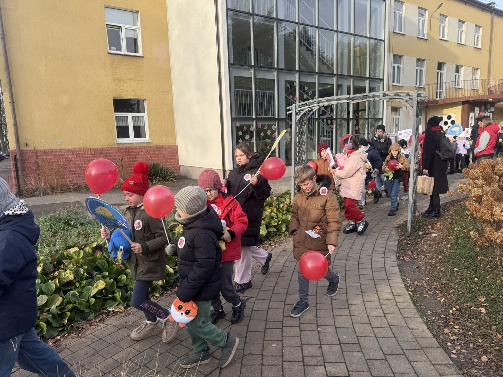 W środę 17.11.2025 nasza szkoła zorganizowała wyjątkowe wydarzenie, które było zaczątkiem podsumowania kampanii „Dzieciństwo bez Przemocy”. Dzień rozpoczął się od radosnego marszu, w którym dzieci grup przedszkolnych z wychowawczyniami oraz uczniowie wraz z nauczycielami przeszli ulicami naszego miasta. Podczas tego wydarzenia dzieci rozdawały mieszkańcom kolorowe maskotki, promując ideę bezpiecznego i szczęśliwego dzieciństwa.
Ważnym punktem dnia było spotkanie w Urzędzie Miasta z panią burmistrz, która serdecznie przyjęła naszych reprezentantów. Rozmowy dotyczyły dalszych działań na rzecz dzieci oraz wspierania inicjatyw mających na celu eliminację przemocy wśród najmłodszych.