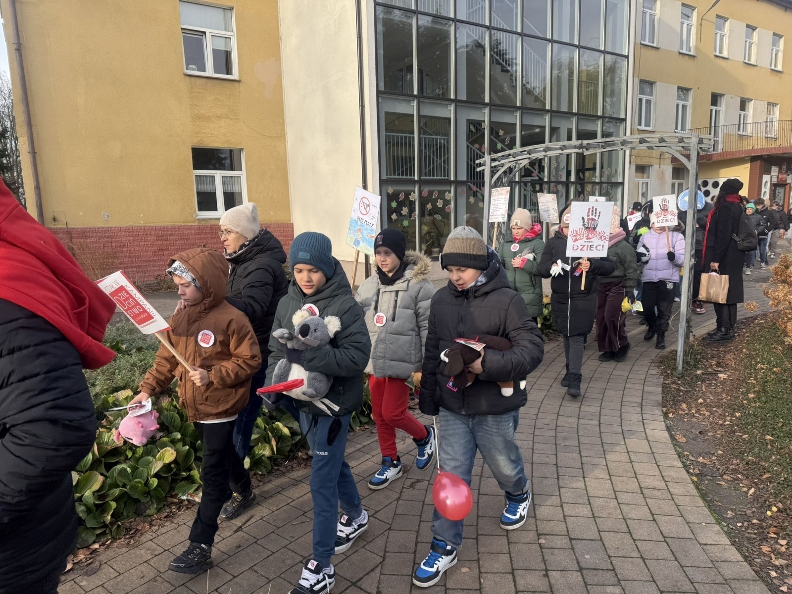 W środę 17.11.2025 nasza szkoła zorganizowała wyjątkowe wydarzenie, które było zaczątkiem podsumowania kampanii „Dzieciństwo bez Przemocy”. Dzień rozpoczął się od radosnego marszu, w którym dzieci grup przedszkolnych z wychowawczyniami oraz uczniowie wraz z nauczycielami przeszli ulicami naszego miasta. Podczas tego wydarzenia dzieci rozdawały mieszkańcom kolorowe maskotki, promując ideę bezpiecznego i szczęśliwego dzieciństwa.
Ważnym punktem dnia było spotkanie w Urzędzie Miasta z panią burmistrz, która serdecznie przyjęła naszych reprezentantów. Rozmowy dotyczyły dalszych działań na rzecz dzieci oraz wspierania inicjatyw mających na celu eliminację przemocy wśród najmłodszych.