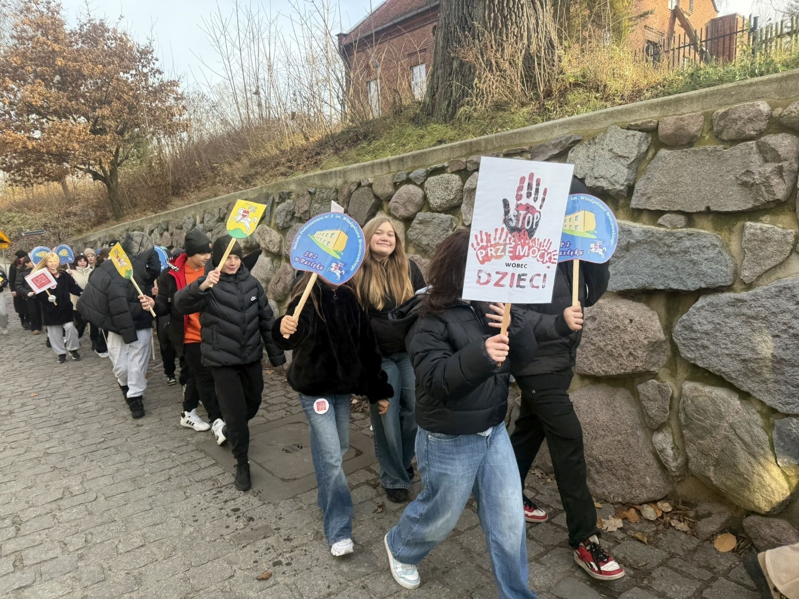 W środę 17.11.2025 nasza szkoła zorganizowała wyjątkowe wydarzenie, które było zaczątkiem podsumowania kampanii „Dzieciństwo bez Przemocy”. Dzień rozpoczął się od radosnego marszu, w którym dzieci grup przedszkolnych z wychowawczyniami oraz uczniowie wraz z nauczycielami przeszli ulicami naszego miasta. Podczas tego wydarzenia dzieci rozdawały mieszkańcom kolorowe maskotki, promując ideę bezpiecznego i szczęśliwego dzieciństwa.
Ważnym punktem dnia było spotkanie w Urzędzie Miasta z panią burmistrz, która serdecznie przyjęła naszych reprezentantów. Rozmowy dotyczyły dalszych działań na rzecz dzieci oraz wspierania inicjatyw mających na celu eliminację przemocy wśród najmłodszych.