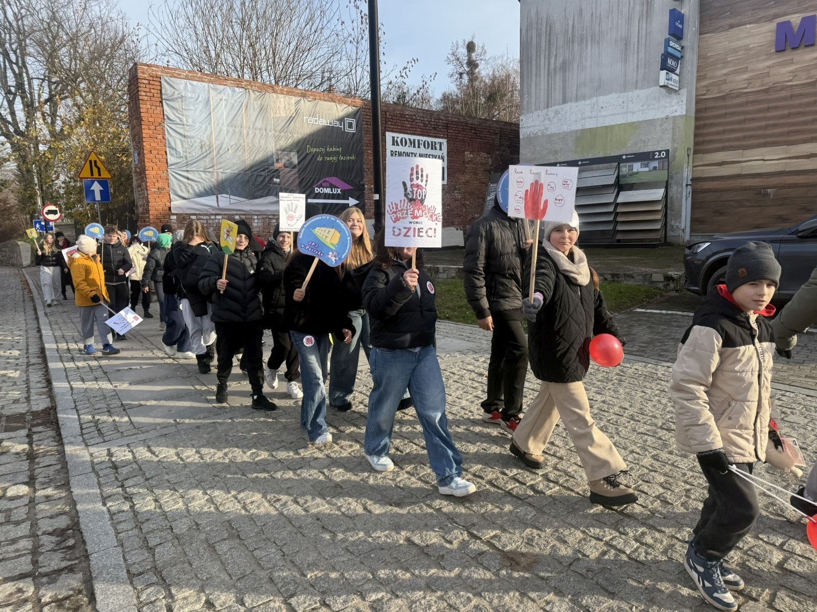 W środę 17.11.2025 nasza szkoła zorganizowała wyjątkowe wydarzenie, które było zaczątkiem podsumowania kampanii „Dzieciństwo bez Przemocy”. Dzień rozpoczął się od radosnego marszu, w którym dzieci grup przedszkolnych z wychowawczyniami oraz uczniowie wraz z nauczycielami przeszli ulicami naszego miasta. Podczas tego wydarzenia dzieci rozdawały mieszkańcom kolorowe maskotki, promując ideę bezpiecznego i szczęśliwego dzieciństwa.
Ważnym punktem dnia było spotkanie w Urzędzie Miasta z panią burmistrz, która serdecznie przyjęła naszych reprezentantów. Rozmowy dotyczyły dalszych działań na rzecz dzieci oraz wspierania inicjatyw mających na celu eliminację przemocy wśród najmłodszych.
