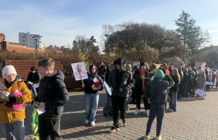 W środę 17.11.2025 nasza szkoła zorganizowała wyjątkowe wydarzenie, które było zaczątkiem podsumowania kampanii „Dzieciństwo bez Przemocy”. Dzień rozpoczął się od radosnego marszu, w którym dzieci grup przedszkolnych z wychowawczyniami oraz uczniowie wraz z nauczycielami przeszli ulicami naszego miasta. Podczas tego wydarzenia dzieci rozdawały mieszkańcom kolorowe maskotki, promując ideę bezpiecznego i szczęśliwego dzieciństwa.
Ważnym punktem dnia było spotkanie w Urzędzie Miasta z panią burmistrz, która serdecznie przyjęła naszych reprezentantów. Rozmowy dotyczyły dalszych działań na rzecz dzieci oraz wspierania inicjatyw mających na celu eliminację przemocy wśród najmłodszych.