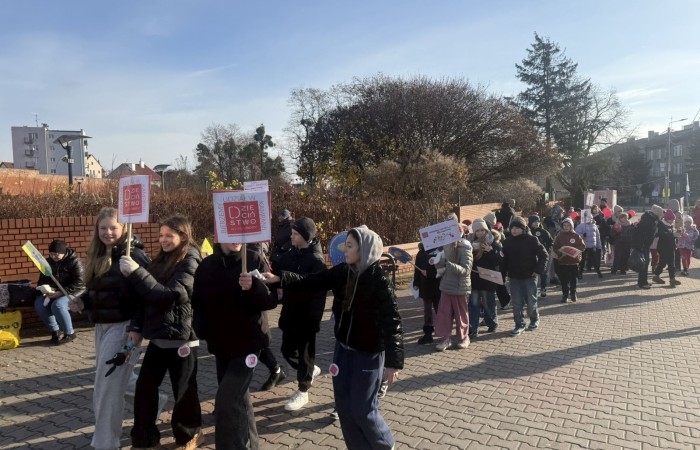 W środę 17.11.2025 nasza szkoła zorganizowała wyjątkowe wydarzenie, które było zaczątkiem podsumowania kampanii „Dzieciństwo bez Przemocy”. Dzień rozpoczął się od radosnego marszu, w którym dzieci grup przedszkolnych z wychowawczyniami oraz uczniowie wraz z nauczycielami przeszli ulicami naszego miasta. Podczas tego wydarzenia dzieci rozdawały mieszkańcom kolorowe maskotki, promując ideę bezpiecznego i szczęśliwego dzieciństwa.
Ważnym punktem dnia było spotkanie w Urzędzie Miasta z panią burmistrz, która serdecznie przyjęła naszych reprezentantów. Rozmowy dotyczyły dalszych działań na rzecz dzieci oraz wspierania inicjatyw mających na celu eliminację przemocy wśród najmłodszych.