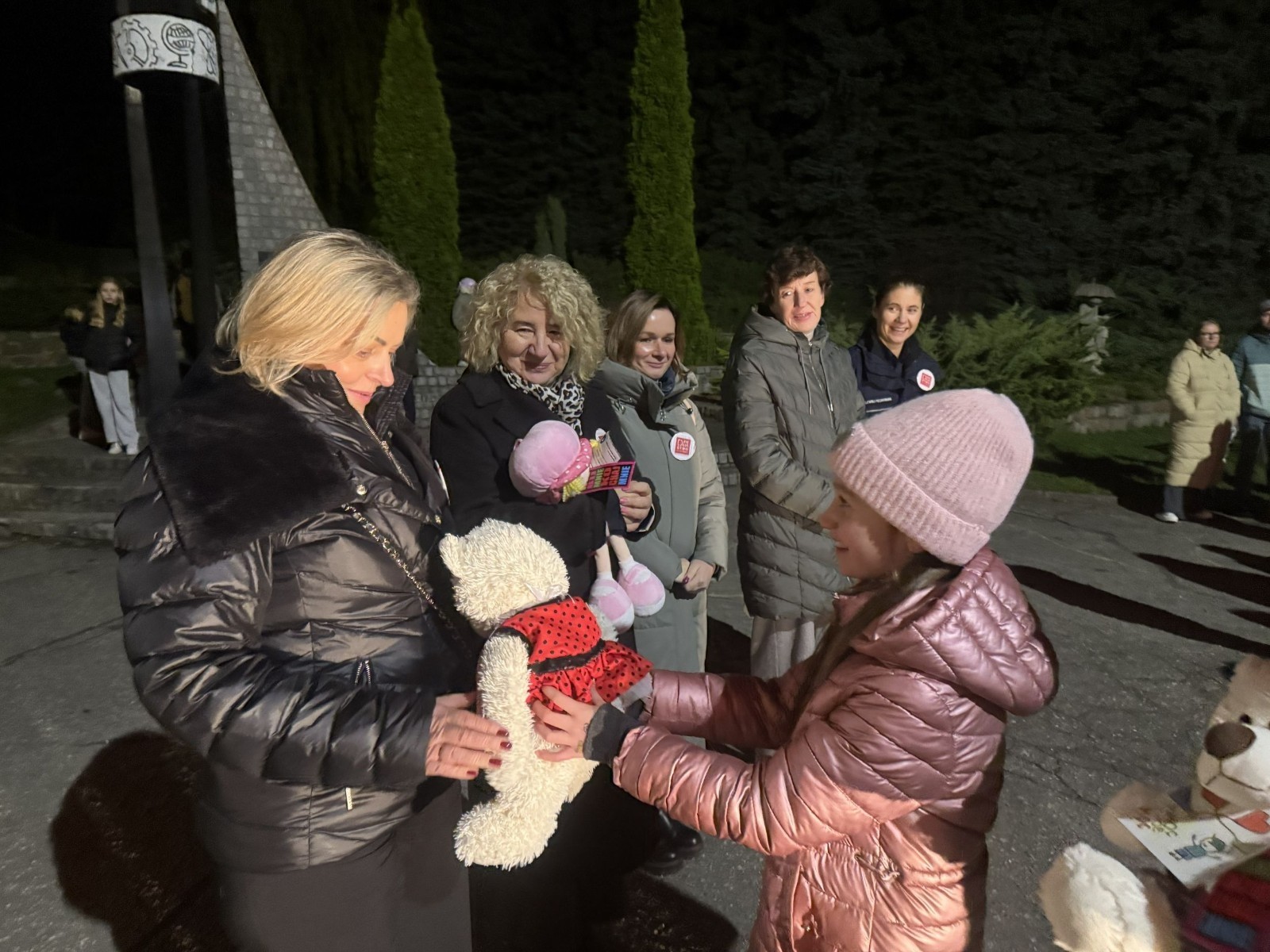 O godzinie 17:00 pod szkołą rozpoczęła się impreza, która zgromadziła około 200 osób. Szkoła została podświetlona na czerwono, co symbolizowało naszą jedność w walce z przemocą. Był to akcent podsumowujący nasze wcześ iej sze  działania w ramach Kampanii Ogólnopolskiej „Dzieciństwo bez Przemocy”. Od października uczniowie uczestniczyli w lekcjach online przygotowanych przez Fundację Dajemy Dzieciom Siłę. Rodzice również zostali objęci wsparciem w postaci webinaru online ww. fudacji.
Uczestnicy mogli wziąć udział w wspólnym śpiewaniu, quizie wiedzy o przemocy oraz tworzeniu „kamieni mocy” – symboli pozytywnej energii i wsparcia. Dodatkowo, w ramach konkursów, przyznano nagrody ufundowane przez Urząd Miejski w Pasłęku.
Ten cudowny czas umilił nam smaczny poczęstunek, w tym grochówka, pizza i ciasta, gorąca kawa i herbatka przygotowany przez panie kucharki i rodziców.
W wydarzeniu uczestniczyli również zaproszeni goście, w tym Burmistrz Pasłęka – pani Elżbieta Wasiuk,  podinspektor KP Pasłęk – pani Agnieszka Bielewicz - Piechowiak oraz przedstawiciel Kuratorium Oświaty w Elblągu – pani Teresa Bednarz, którzy wspierają nasze działania. Ich obecność była dowodem na to, jak ważna jest współpraca lokalnej społeczności w walce z przemocą wobec dzieci. Dziękujemy wszystkim, którzy wzięli udział w tym wyjątkowym dniu oraz przyczynili się do jego organizacji. Razem możemy stworzyć bezpieczne i przyjazne środowisko dla naszych dzieci!
