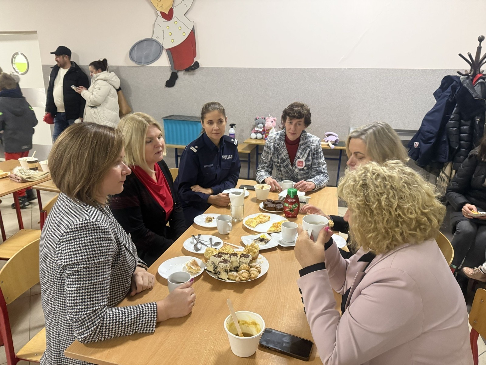 O godzinie 17:00 pod szkołą rozpoczęła się impreza, która zgromadziła około 200 osób. Szkoła została podświetlona na czerwono, co symbolizowało naszą jedność w walce z przemocą. Był to akcent podsumowujący nasze wcześ iej sze  działania w ramach Kampanii Ogólnopolskiej „Dzieciństwo bez Przemocy”. Od października uczniowie uczestniczyli w lekcjach online przygotowanych przez Fundację Dajemy Dzieciom Siłę. Rodzice również zostali objęci wsparciem w postaci webinaru online ww. fudacji.
Uczestnicy mogli wziąć udział w wspólnym śpiewaniu, quizie wiedzy o przemocy oraz tworzeniu „kamieni mocy” – symboli pozytywnej energii i wsparcia. Dodatkowo, w ramach konkursów, przyznano nagrody ufundowane przez Urząd Miejski w Pasłęku.
Ten cudowny czas umilił nam smaczny poczęstunek, w tym grochówka, pizza i ciasta, gorąca kawa i herbatka przygotowany przez panie kucharki i rodziców.
W wydarzeniu uczestniczyli również zaproszeni goście, w tym Burmistrz Pasłęka – pani Elżbieta Wasiuk,  podinspektor KP Pasłęk – pani Agnieszka Bielewicz - Piechowiak oraz przedstawiciel Kuratorium Oświaty w Elblągu – pani Teresa Bednarz, którzy wspierają nasze działania. Ich obecność była dowodem na to, jak ważna jest współpraca lokalnej społeczności w walce z przemocą wobec dzieci. Dziękujemy wszystkim, którzy wzięli udział w tym wyjątkowym dniu oraz przyczynili się do jego organizacji. Razem możemy stworzyć bezpieczne i przyjazne środowisko dla naszych dzieci!
