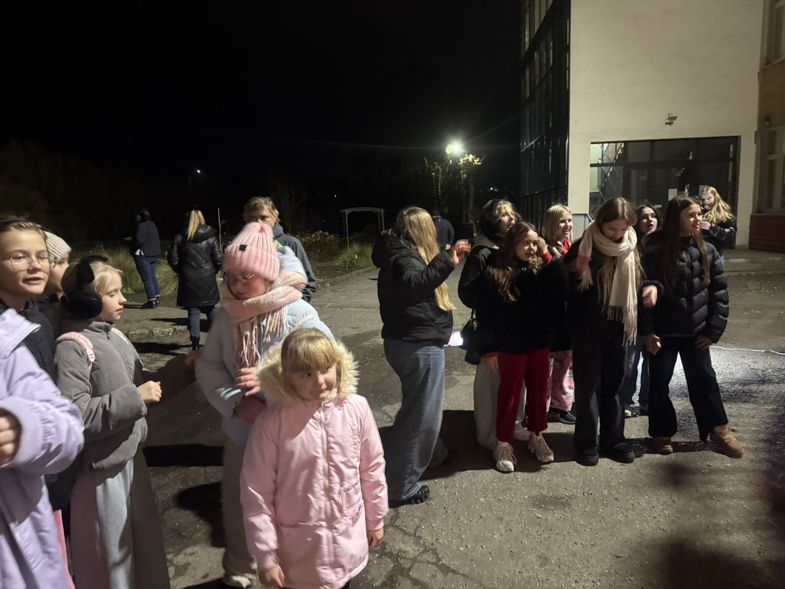 O godzinie 17:00 pod szkołą rozpoczęła się impreza, która zgromadziła około 200 osób. Szkoła została podświetlona na czerwono, co symbolizowało naszą jedność w walce z przemocą. Był to akcent podsumowujący nasze wcześ iej sze  działania w ramach Kampanii Ogólnopolskiej „Dzieciństwo bez Przemocy”. Od października uczniowie uczestniczyli w lekcjach online przygotowanych przez Fundację Dajemy Dzieciom Siłę. Rodzice również zostali objęci wsparciem w postaci webinaru online ww. fudacji.
Uczestnicy mogli wziąć udział w wspólnym śpiewaniu, quizie wiedzy o przemocy oraz tworzeniu „kamieni mocy” – symboli pozytywnej energii i wsparcia. Dodatkowo, w ramach konkursów, przyznano nagrody ufundowane przez Urząd Miejski w Pasłęku.
Ten cudowny czas umilił nam smaczny poczęstunek, w tym grochówka, pizza i ciasta, gorąca kawa i herbatka przygotowany przez panie kucharki i rodziców.
W wydarzeniu uczestniczyli również zaproszeni goście, w tym Burmistrz Pasłęka – pani Elżbieta Wasiuk,  podinspektor KP Pasłęk – pani Agnieszka Bielewicz - Piechowiak oraz przedstawiciel Kuratorium Oświaty w Elblągu – pani Teresa Bednarz, którzy wspierają nasze działania. Ich obecność była dowodem na to, jak ważna jest współpraca lokalnej społeczności w walce z przemocą wobec dzieci. Dziękujemy wszystkim, którzy wzięli udział w tym wyjątkowym dniu oraz przyczynili się do jego organizacji. Razem możemy stworzyć bezpieczne i przyjazne środowisko dla naszych dzieci!
