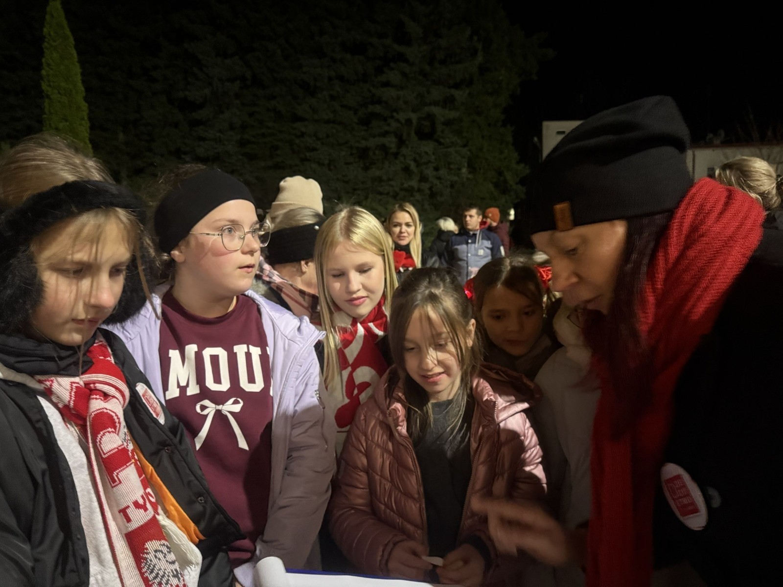 O godzinie 17:00 pod szkołą rozpoczęła się impreza, która zgromadziła około 200 osób. Szkoła została podświetlona na czerwono, co symbolizowało naszą jedność w walce z przemocą. Był to akcent podsumowujący nasze wcześ iej sze  działania w ramach Kampanii Ogólnopolskiej „Dzieciństwo bez Przemocy”. Od października uczniowie uczestniczyli w lekcjach online przygotowanych przez Fundację Dajemy Dzieciom Siłę. Rodzice również zostali objęci wsparciem w postaci webinaru online ww. fudacji.
Uczestnicy mogli wziąć udział w wspólnym śpiewaniu, quizie wiedzy o przemocy oraz tworzeniu „kamieni mocy” – symboli pozytywnej energii i wsparcia. Dodatkowo, w ramach konkursów, przyznano nagrody ufundowane przez Urząd Miejski w Pasłęku.
Ten cudowny czas umilił nam smaczny poczęstunek, w tym grochówka, pizza i ciasta, gorąca kawa i herbatka przygotowany przez panie kucharki i rodziców.
W wydarzeniu uczestniczyli również zaproszeni goście, w tym Burmistrz Pasłęka – pani Elżbieta Wasiuk,  podinspektor KP Pasłęk – pani Agnieszka Bielewicz - Piechowiak oraz przedstawiciel Kuratorium Oświaty w Elblągu – pani Teresa Bednarz, którzy wspierają nasze działania. Ich obecność była dowodem na to, jak ważna jest współpraca lokalnej społeczności w walce z przemocą wobec dzieci. Dziękujemy wszystkim, którzy wzięli udział w tym wyjątkowym dniu oraz przyczynili się do jego organizacji. Razem możemy stworzyć bezpieczne i przyjazne środowisko dla naszych dzieci!
