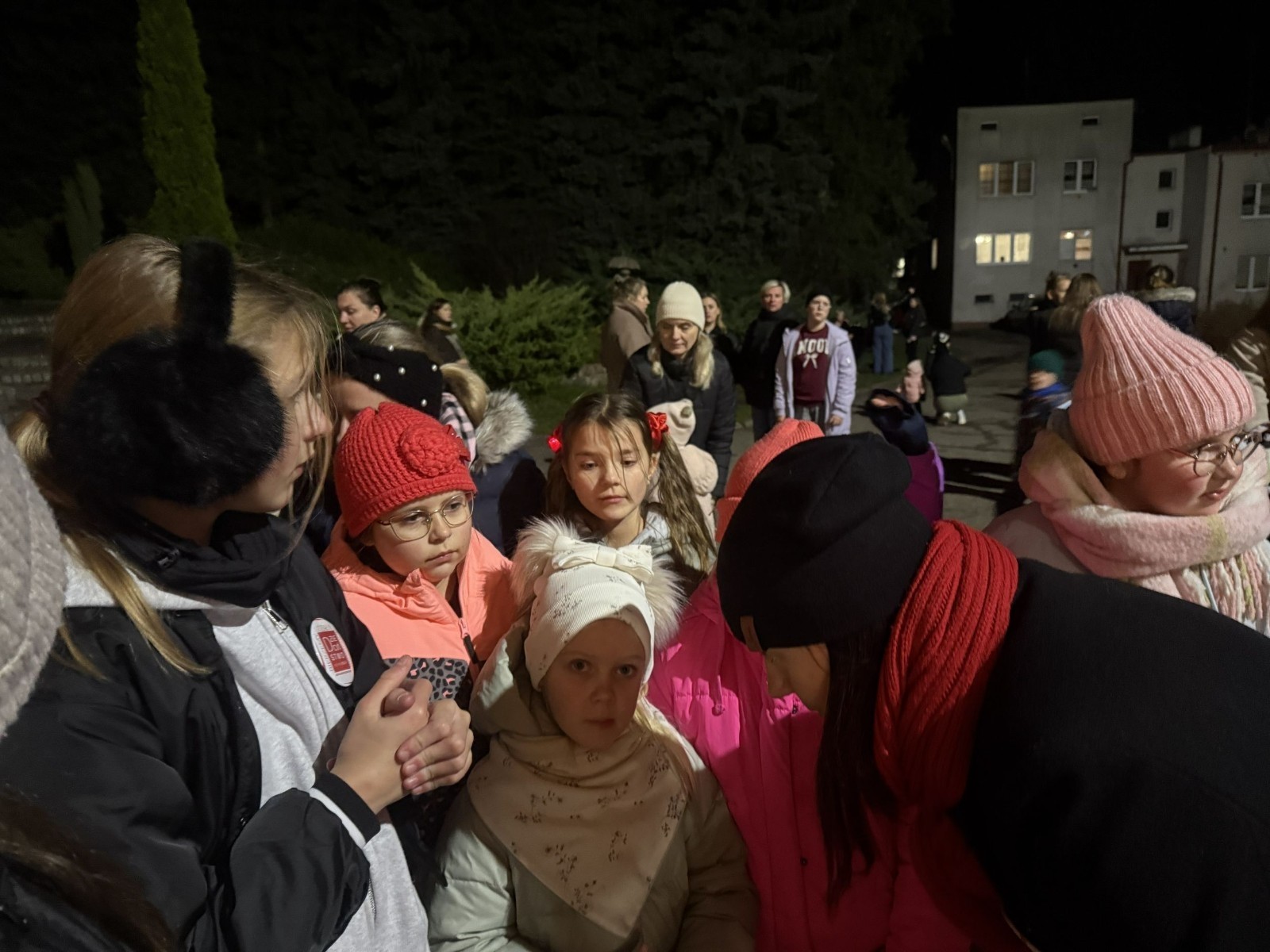 O godzinie 17:00 pod szkołą rozpoczęła się impreza, która zgromadziła około 200 osób. Szkoła została podświetlona na czerwono, co symbolizowało naszą jedność w walce z przemocą. Był to akcent podsumowujący nasze wcześ iej sze  działania w ramach Kampanii Ogólnopolskiej „Dzieciństwo bez Przemocy”. Od października uczniowie uczestniczyli w lekcjach online przygotowanych przez Fundację Dajemy Dzieciom Siłę. Rodzice również zostali objęci wsparciem w postaci webinaru online ww. fudacji.
Uczestnicy mogli wziąć udział w wspólnym śpiewaniu, quizie wiedzy o przemocy oraz tworzeniu „kamieni mocy” – symboli pozytywnej energii i wsparcia. Dodatkowo, w ramach konkursów, przyznano nagrody ufundowane przez Urząd Miejski w Pasłęku.
Ten cudowny czas umilił nam smaczny poczęstunek, w tym grochówka, pizza i ciasta, gorąca kawa i herbatka przygotowany przez panie kucharki i rodziców.
W wydarzeniu uczestniczyli również zaproszeni goście, w tym Burmistrz Pasłęka – pani Elżbieta Wasiuk,  podinspektor KP Pasłęk – pani Agnieszka Bielewicz - Piechowiak oraz przedstawiciel Kuratorium Oświaty w Elblągu – pani Teresa Bednarz, którzy wspierają nasze działania. Ich obecność była dowodem na to, jak ważna jest współpraca lokalnej społeczności w walce z przemocą wobec dzieci. Dziękujemy wszystkim, którzy wzięli udział w tym wyjątkowym dniu oraz przyczynili się do jego organizacji. Razem możemy stworzyć bezpieczne i przyjazne środowisko dla naszych dzieci!
