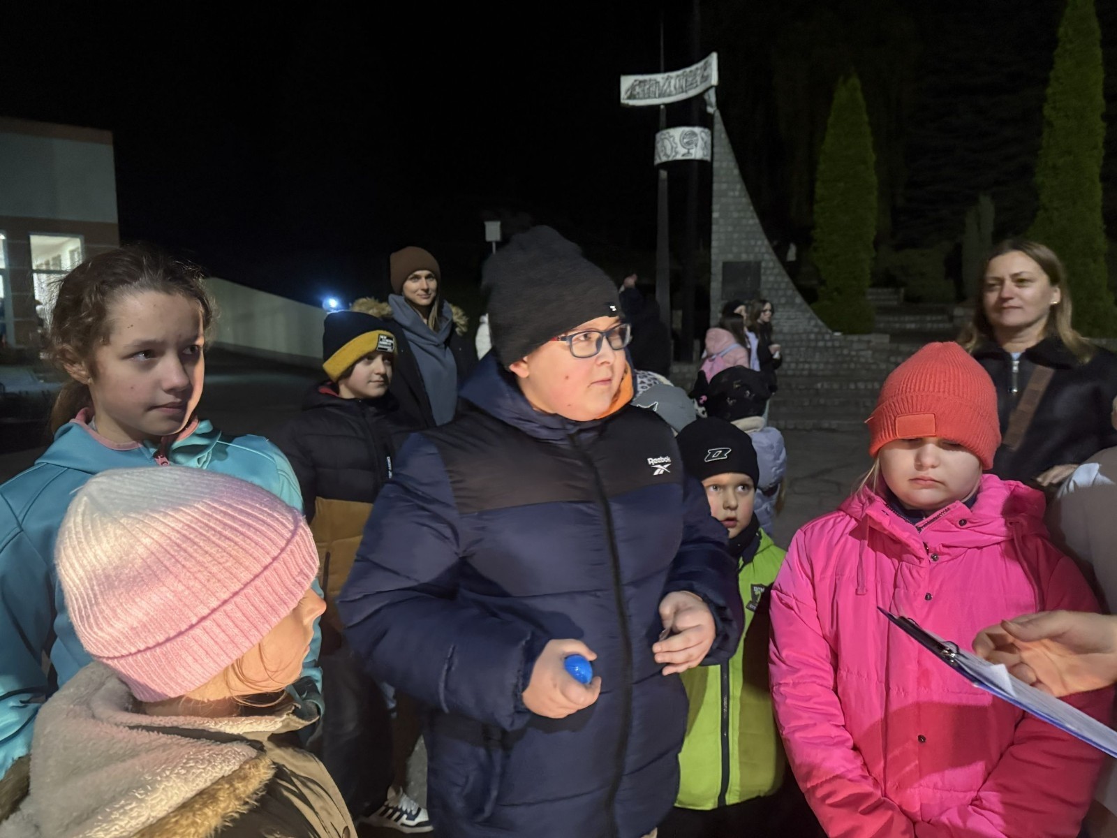 O godzinie 17:00 pod szkołą rozpoczęła się impreza, która zgromadziła około 200 osób. Szkoła została podświetlona na czerwono, co symbolizowało naszą jedność w walce z przemocą. Był to akcent podsumowujący nasze wcześ iej sze  działania w ramach Kampanii Ogólnopolskiej „Dzieciństwo bez Przemocy”. Od października uczniowie uczestniczyli w lekcjach online przygotowanych przez Fundację Dajemy Dzieciom Siłę. Rodzice również zostali objęci wsparciem w postaci webinaru online ww. fudacji.
Uczestnicy mogli wziąć udział w wspólnym śpiewaniu, quizie wiedzy o przemocy oraz tworzeniu „kamieni mocy” – symboli pozytywnej energii i wsparcia. Dodatkowo, w ramach konkursów, przyznano nagrody ufundowane przez Urząd Miejski w Pasłęku.
Ten cudowny czas umilił nam smaczny poczęstunek, w tym grochówka, pizza i ciasta, gorąca kawa i herbatka przygotowany przez panie kucharki i rodziców.
W wydarzeniu uczestniczyli również zaproszeni goście, w tym Burmistrz Pasłęka – pani Elżbieta Wasiuk,  podinspektor KP Pasłęk – pani Agnieszka Bielewicz - Piechowiak oraz przedstawiciel Kuratorium Oświaty w Elblągu – pani Teresa Bednarz, którzy wspierają nasze działania. Ich obecność była dowodem na to, jak ważna jest współpraca lokalnej społeczności w walce z przemocą wobec dzieci. Dziękujemy wszystkim, którzy wzięli udział w tym wyjątkowym dniu oraz przyczynili się do jego organizacji. Razem możemy stworzyć bezpieczne i przyjazne środowisko dla naszych dzieci!
