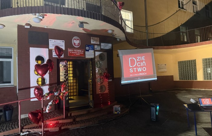 O godzinie 17:00 pod szkołą rozpoczęła się impreza, która zgromadziła około 200 osób. Szkoła została podświetlona na czerwono, co symbolizowało naszą jedność w walce z przemocą. Był to akcent podsumowujący nasze wcześ iej sze  działania w ramach Kampanii Ogólnopolskiej „Dzieciństwo bez Przemocy”. Od października uczniowie uczestniczyli w lekcjach online przygotowanych przez Fundację Dajemy Dzieciom Siłę. Rodzice również zostali objęci wsparciem w postaci webinaru online ww. fudacji.
Uczestnicy mogli wziąć udział w wspólnym śpiewaniu, quizie wiedzy o przemocy oraz tworzeniu „kamieni mocy” – symboli pozytywnej energii i wsparcia. Dodatkowo, w ramach konkursów, przyznano nagrody ufundowane przez Urząd Miejski w Pasłęku.
Ten cudowny czas umilił nam smaczny poczęstunek, w tym grochówka, pizza i ciasta, gorąca kawa i herbatka przygotowany przez panie kucharki i rodziców.
W wydarzeniu uczestniczyli również zaproszeni goście, w tym Burmistrz Pasłęka – pani Elżbieta Wasiuk,  podinspektor KP Pasłęk – pani Agnieszka Bielewicz - Piechowiak oraz przedstawiciel Kuratorium Oświaty w Elblągu – pani Teresa Bednarz, którzy wspierają nasze działania. Ich obecność była dowodem na to, jak ważna jest współpraca lokalnej społeczności w walce z przemocą wobec dzieci. Dziękujemy wszystkim, którzy wzięli udział w tym wyjątkowym dniu oraz przyczynili się do jego organizacji. Razem możemy stworzyć bezpieczne i przyjazne środowisko dla naszych dzieci!
